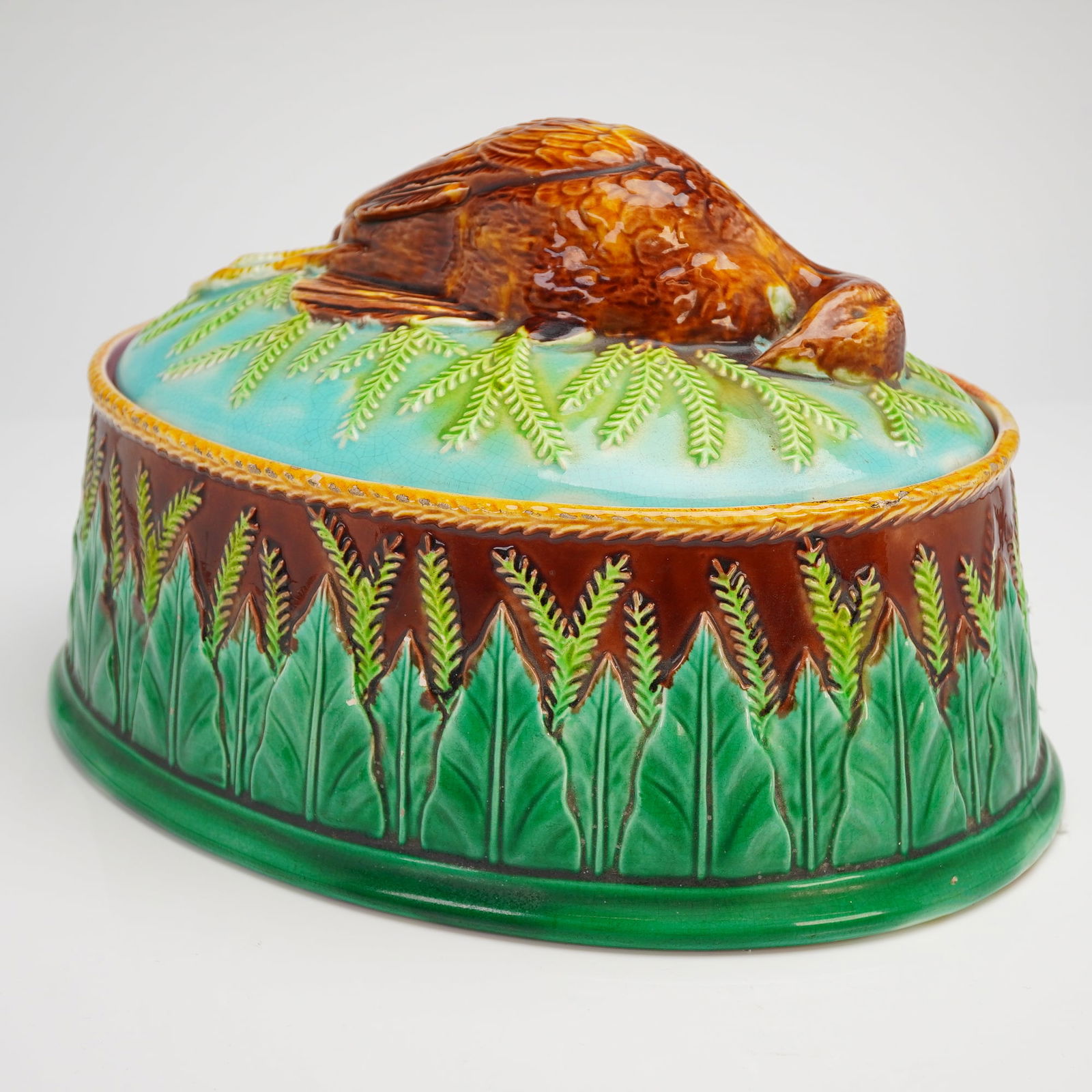 George Jones Majolica Partridge Game Pie Dish with Lid: A single George Jones Majolica Partridge Game Pie Dish with Lid, dating stylistically to the late Victorian era. This ceramic terrine is composed of an oval base and a fitted domed cover, executed in