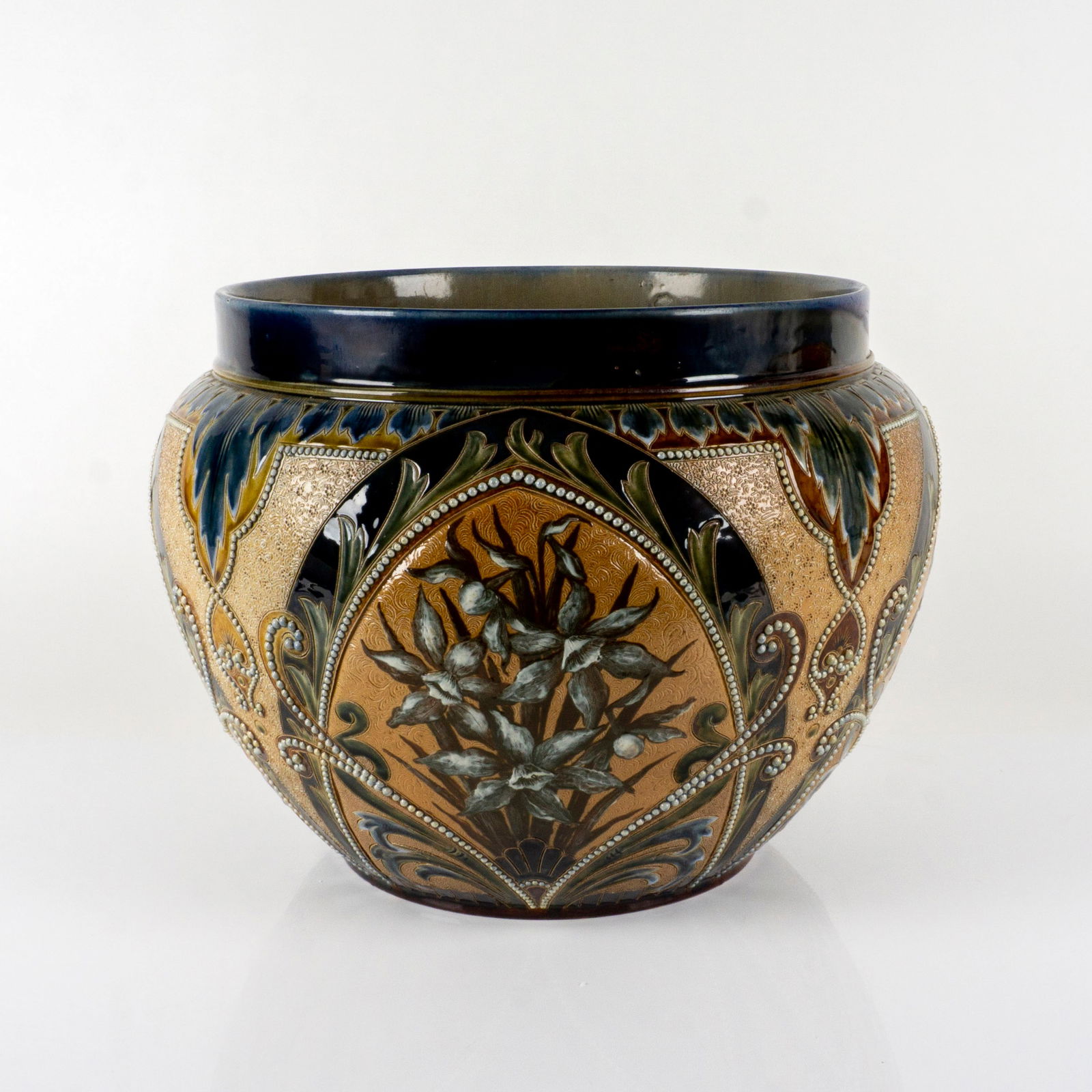 Doulton Lambeth Large Art Nouveau Eliza Simmance Jardiniere: Monumental Glazed Stoneware piece. High Relief Pierced Daffodil Flowers Decorations. Two Doulton marks to the inside of a rim. Artist: Eliza Simmance Dimensions: 14" H x 14.5" Diameter Country of Orig