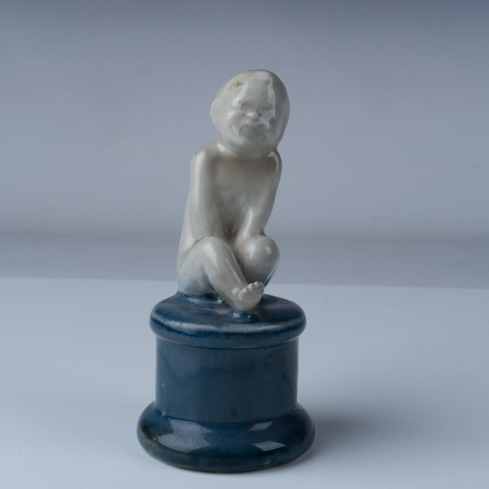 Royal Doulton Leslie Harradine Figurine, Child Study H48: A captivating Royal Doulton glazed buff stoneware figure titled Amused Child Study, designed by Leslie Harradine. This rare piece showcases a seated child with a serene and contemplative expression, c