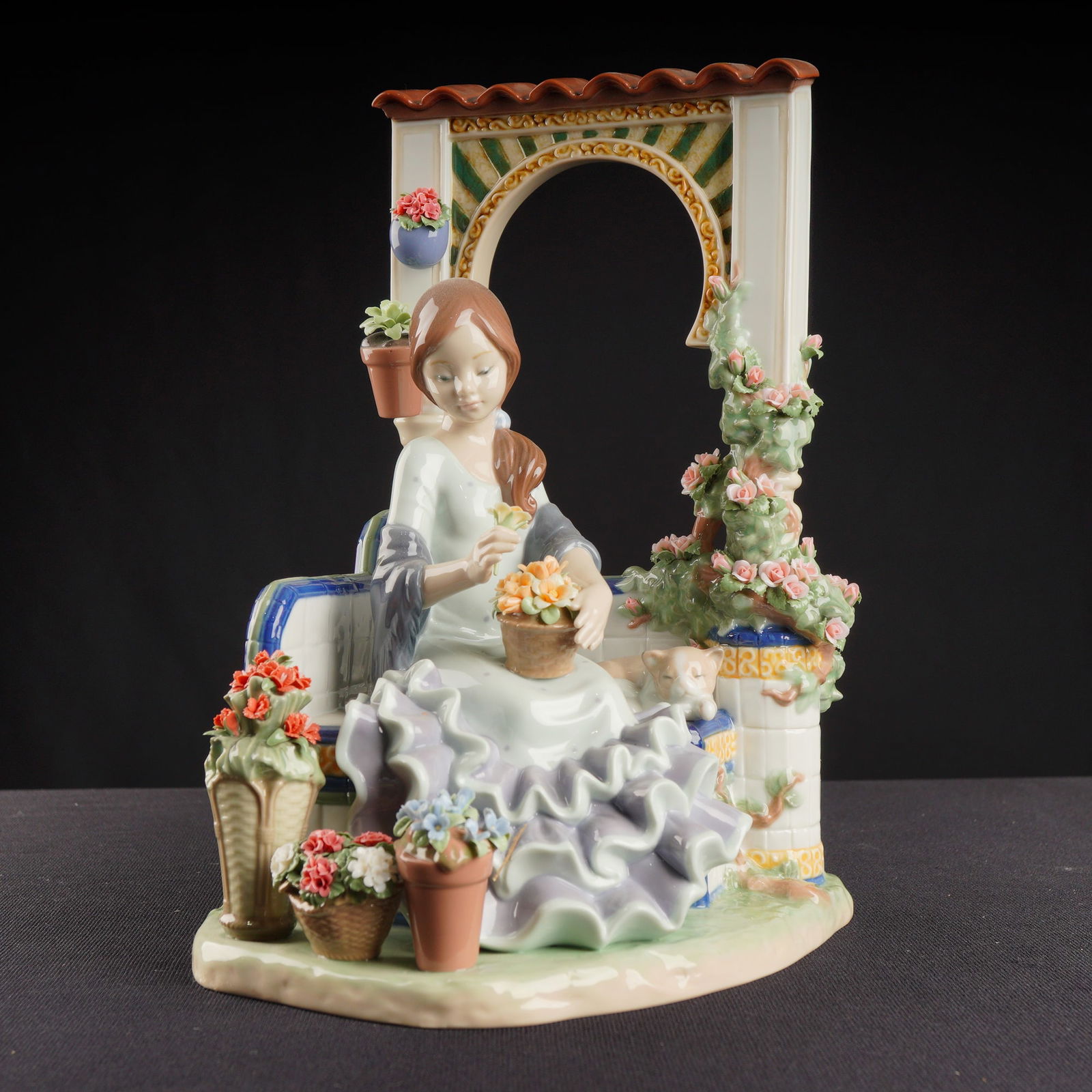 Lladro Porcelain Figurine Andalusian Spring 01001964: A limited edition Lladro Porcelain Figurine, titled "Andalusian Spring" (Ref. 01001964), rendered in high-gloss Spanish porcelain. The sculpture depicts a young woman in a dramatic ruffled dress seate