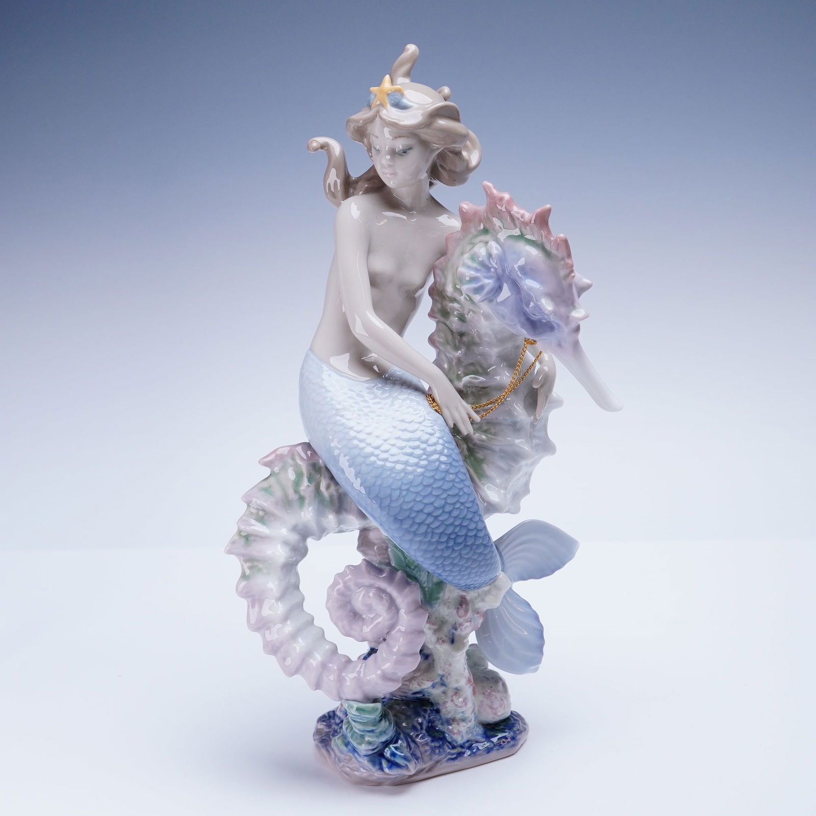 Lladro Porcelain Sculpture Beneath the Waves 01001822: The limited-edition sculpture, number 204 of 2500, depicts a mermaid seated astride a large, intricately detailed seahorse. The figure is executed in glazed porcelain using the characteristic soft, pa