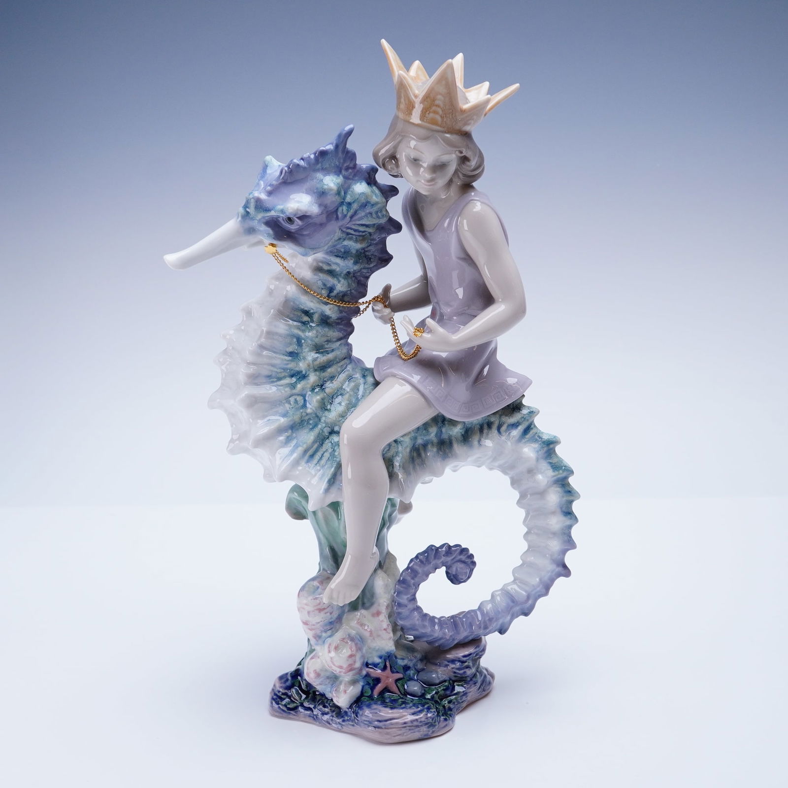 Lladro Porcelain Sculpture Prince of the Sea 01001821: This limited edition, number 73 of 2500, figurine depicts a young figure, identified as a prince, wearing a pale lavender tunic and a stylized beige crown, mounted atop a large, intricately detailed