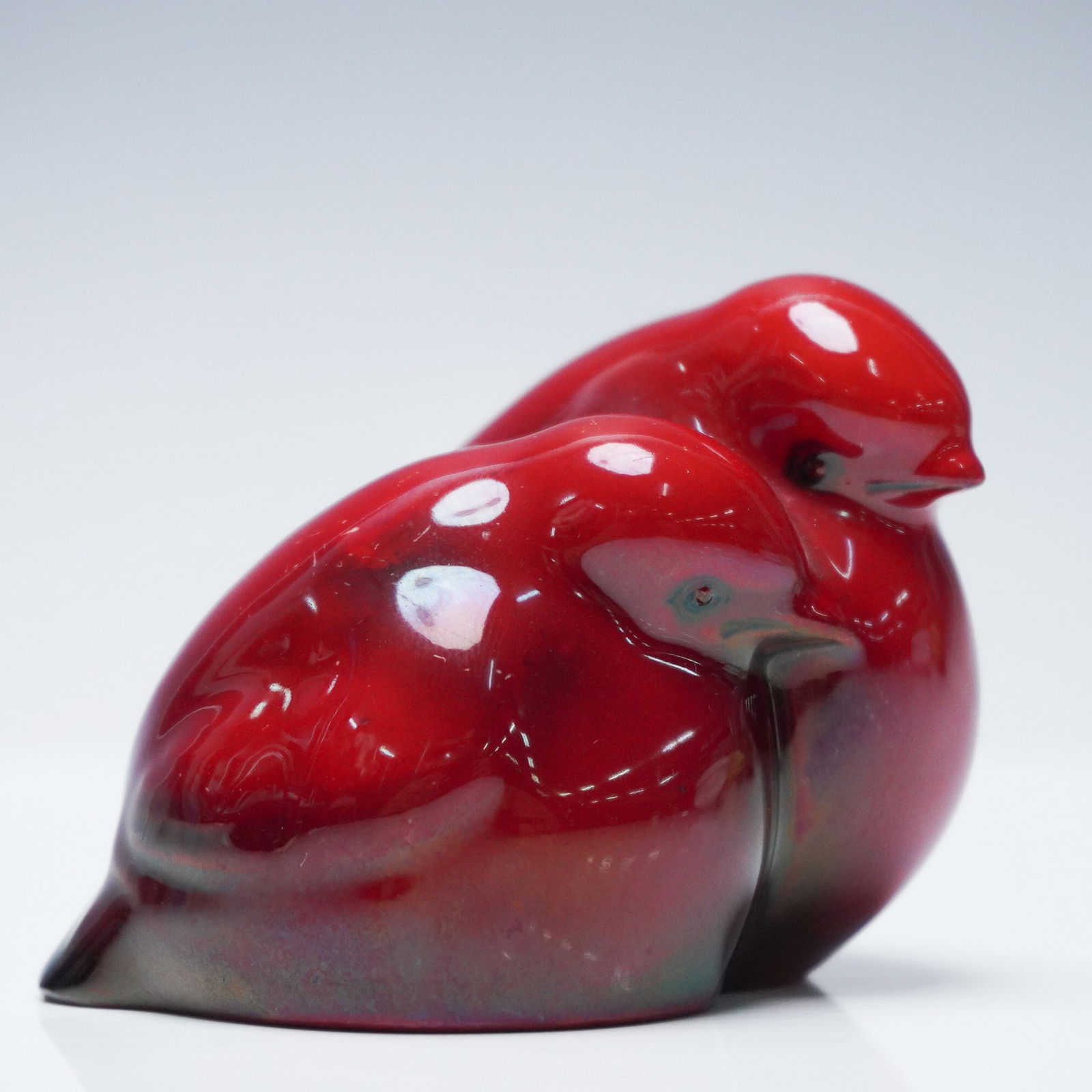 Royal Doulton Flambe Animal Figurine, Chicks - Two HN236: The piece depicts two baby birds nestled together in a seated pose. This example is finished in a lustre flambe glaze, which produces a high-gloss red surface with tonal variation ranging from deep cr