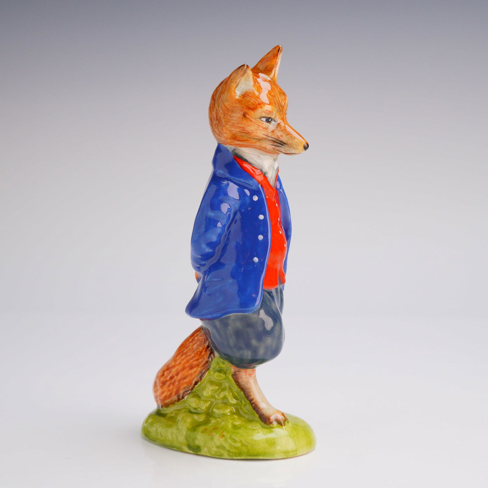 Royal Doulton Prototype Beatrix Potter Figurine, Foxy Whiskered Gentleman: A very rare prototype depicting the Foxy Whiskered Gentleman in a white buttoned blue jacket, white buttoned red waistcoat and tweedy grey breeches. The distinctive bold colors contrast with the stand