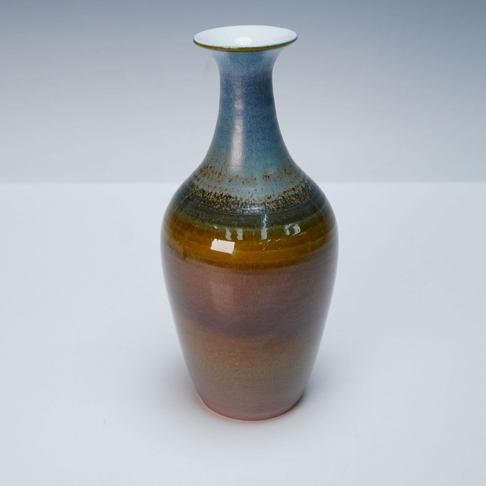 Wedgwood by Elwyn James Bone China Vase: A bone china vase, dating to circa 1970. The vase features an attenuated form with a flaring rim, slender neck, and a gently widening body that tapers to a narrow foot. It is adorned with a multi-tona