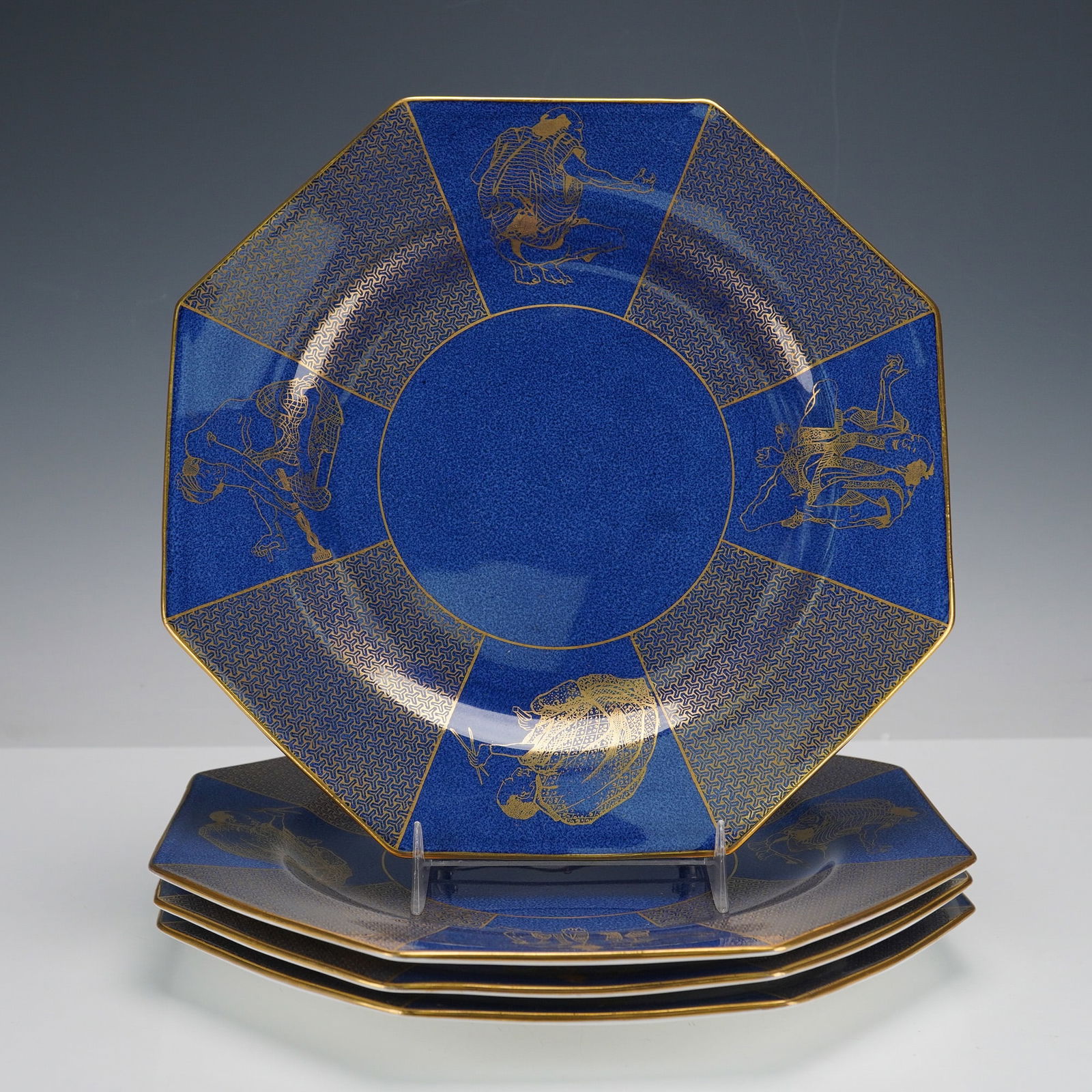 Set of Four Wedgwood Blue Chinoiserie Gilt Decorated Octagonal Plates: A set of four Wedgwood octagonal plates, featuring a powdered blue (bleu souffle) porcelain ground with extensive gilt decoration. Each plate's design includes a central circular well surrounded by ei