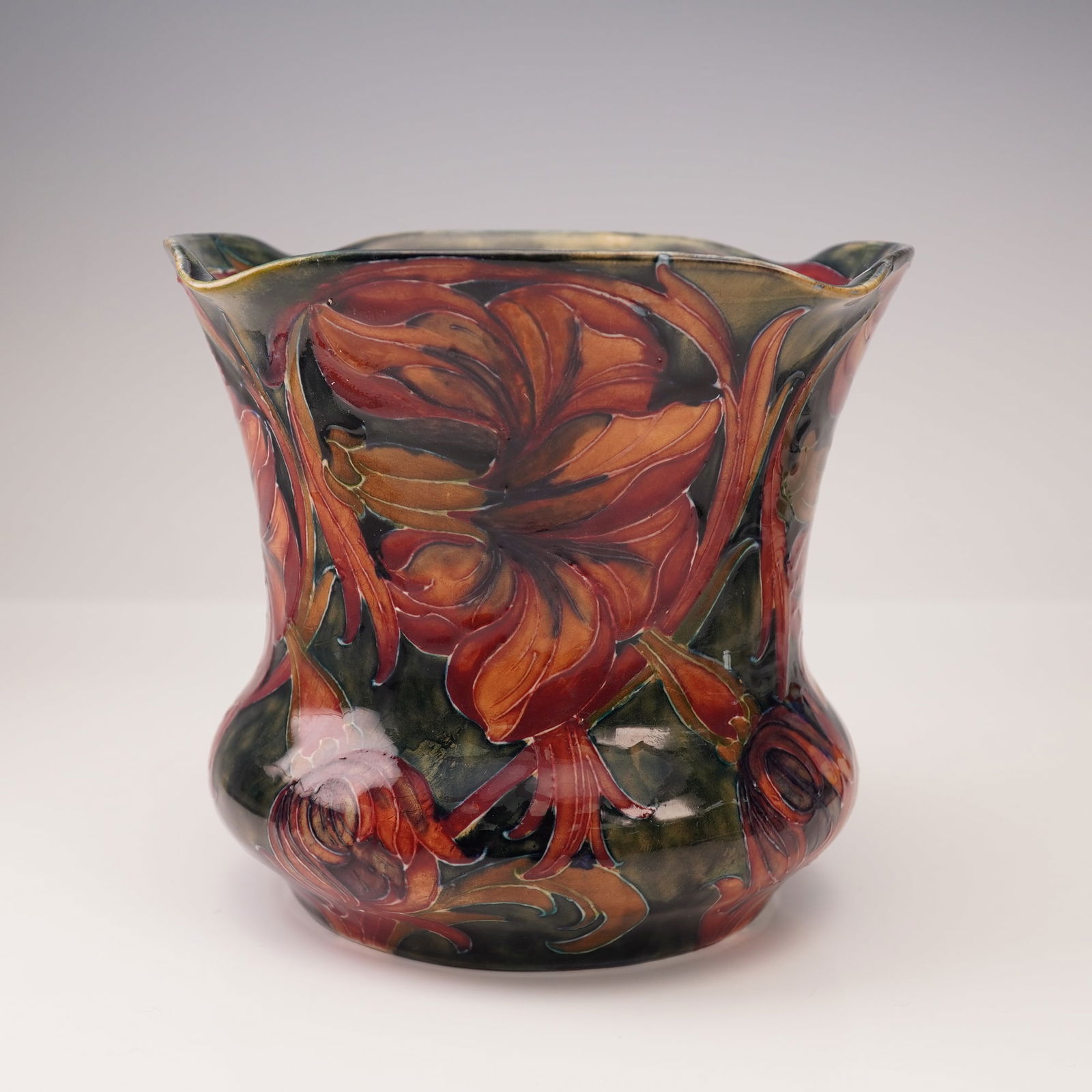 William Moorcroft Pottery Planter, Spanish: A very early vessel decorated in the celebrated "Spanish" pattern. With flared rim, the planter is decorated with richly glazed cyclamen-like blooms with undulating foliage. The blossoms are