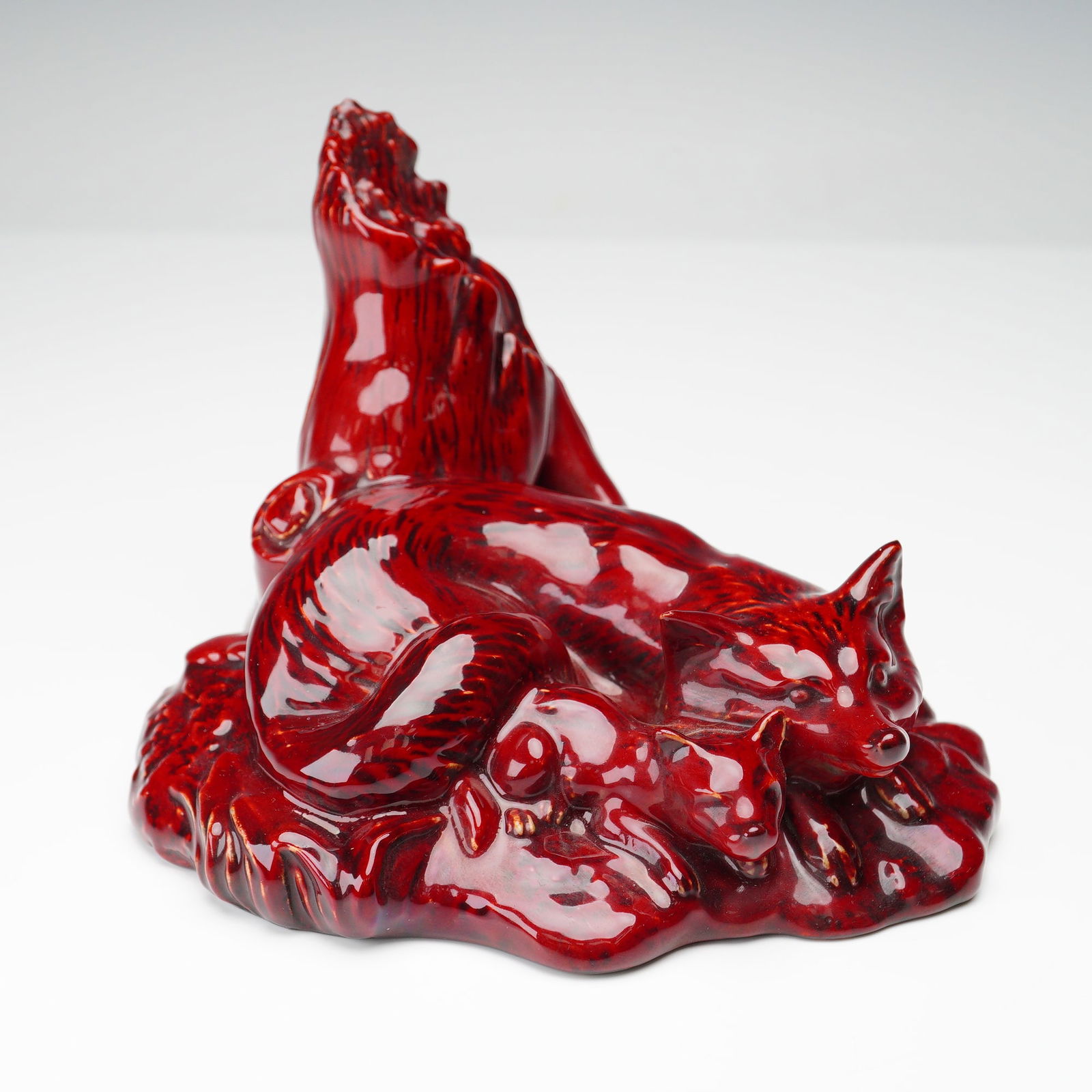 Royal Doulton Flambe Colorway Figurine, Fox DA10: A striking Royal Doulton porcelain figurine from The Wildlife Collection, model DA10, titled Fox (sometimes Fox with Cub), depicting a fox and her cub resting beside a tree stump. Rendered in the rich