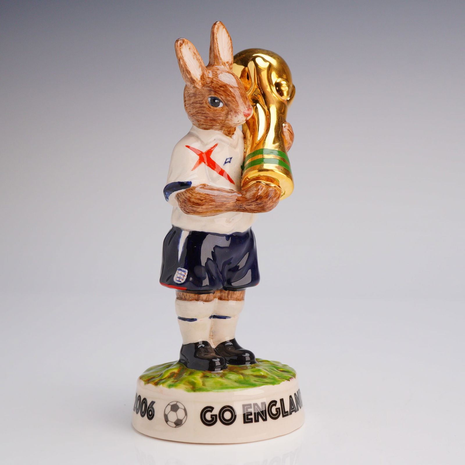 Royal Doulton Prototype Figurine, Winner's Trophy 2006 Bunnykins: Outstanding rare prototype of the Winner's Trophy 2006 Bunnykins outfitted in the 2006 England kit: white shirt with stylized red St George's Cross, team logo, dark blue chevrons, dark blue shorts