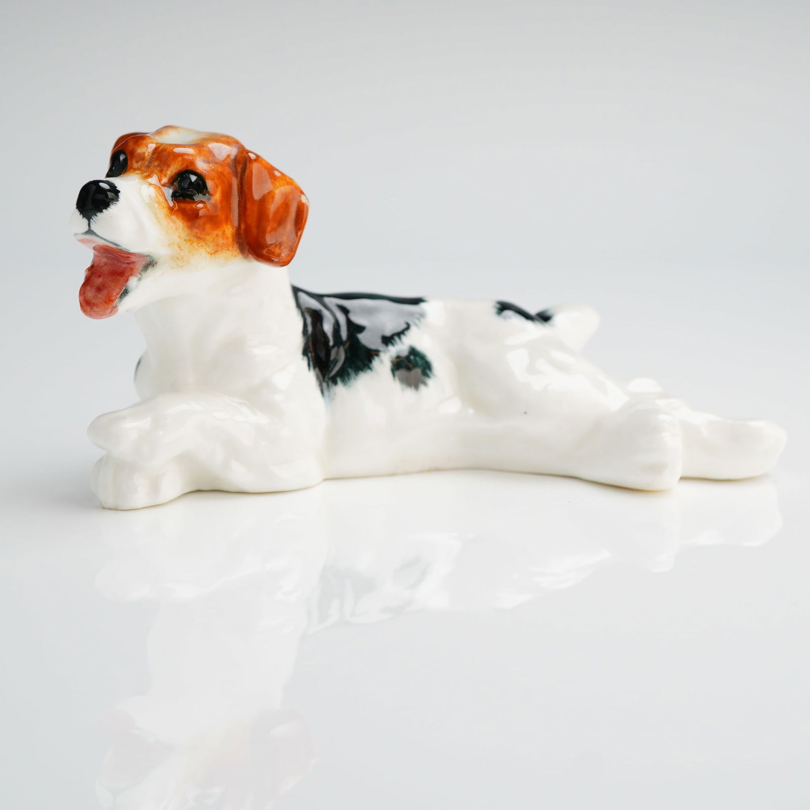 Royal Doulton Character Dog Figurine Lying Panting HN1101: A single glazed ceramic figurine identified as the Royal Doulton Character Dog, model number HN1101. The figurine depicts a Terrier-type dog in a recumbent or lying position with its mouth open,