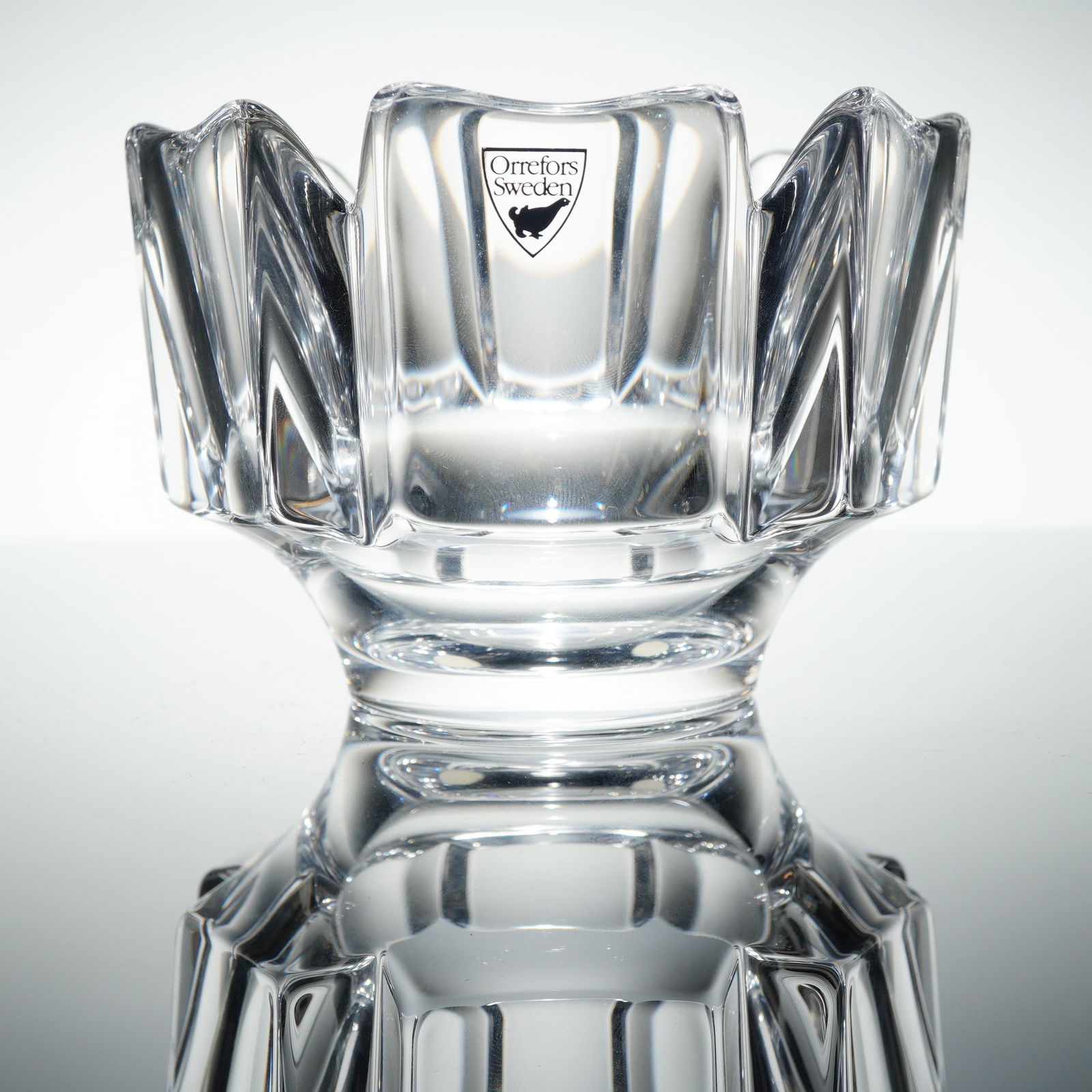 Orrefors Corona Crystal Bowl by Lars Hellsten: A single Orrefors Crystal bowl in the 'Corona' patern, designed by Lars Hellsten. This piece features heavy, thick-walled clear crystal construction with a geometric, heavily faceted design typical of