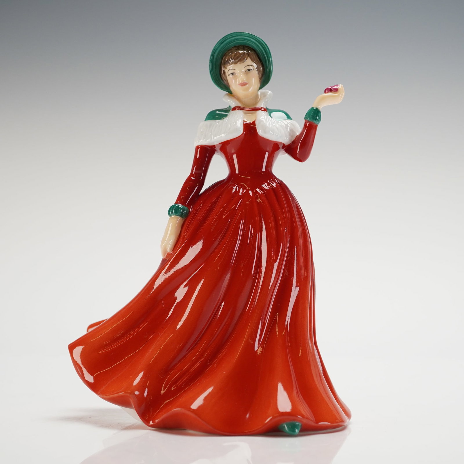 Royal Doulton Winter's Day Figurine HN 4589 with Presentation Box: A Royal Doulton bone china figurine, titled "Winter's Day," model number HN 4589, presented with its original presentation box. The figurine is hand-made and hand-decorated, depicting a woman in a flo