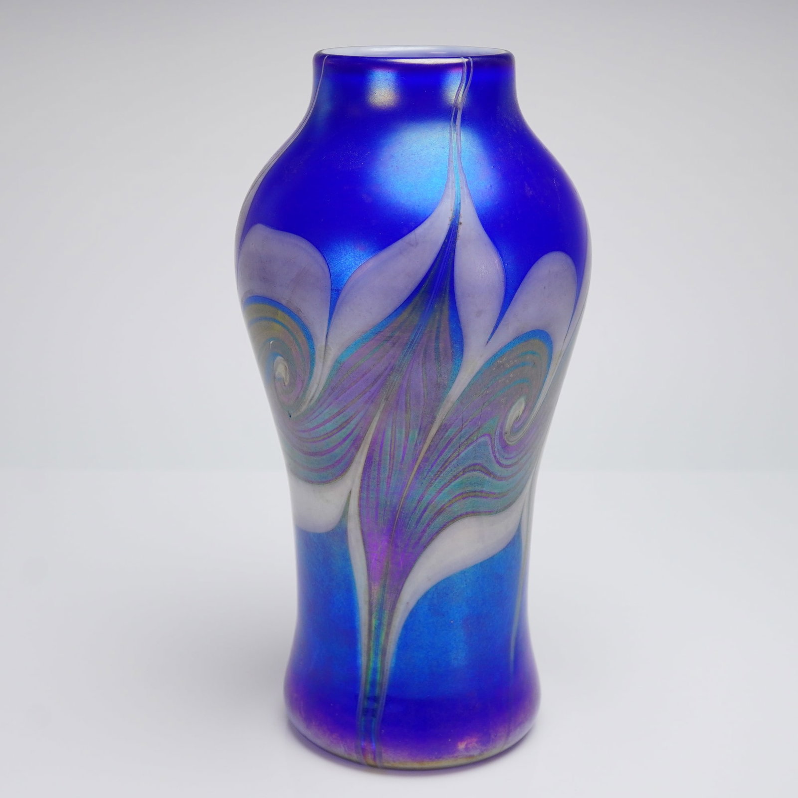 Vandermark Signed Iridescent Feather Art Glass Vase: A single Art Glass vase by Vandermark. The piece features a baluster form with a constricted neck, executed in iridescent cobalt blue glass with a heavy satin finish. The exterior decoration utilizes