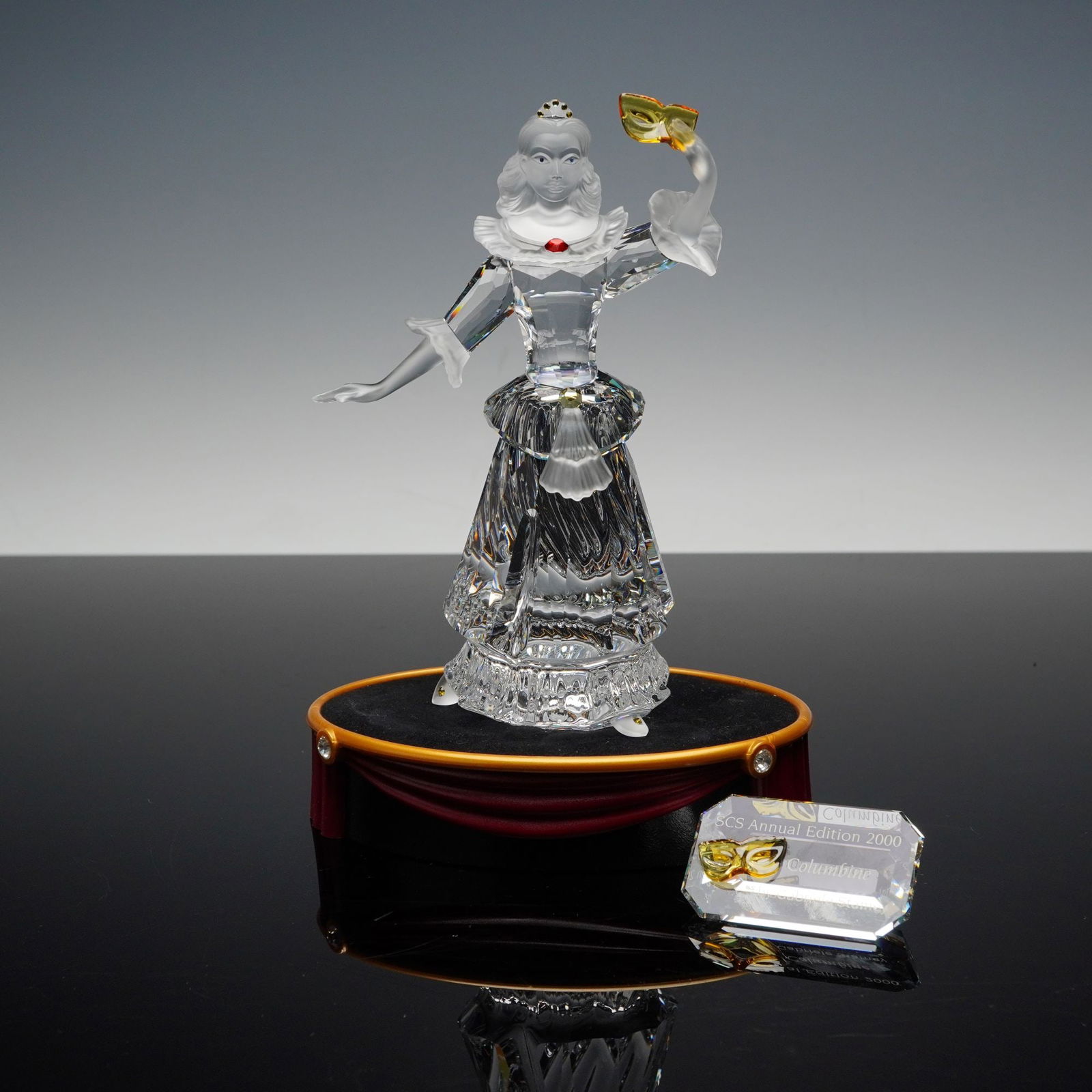 Swarovski SCS Annual Edition 2000 Columbine Figurine Set 242032: The lot consists of the Swarovski Crystal Society (SCS) Annual Edition 2000 figurine, "Columbine," designed by Gabriele Stamey. The set includes the main figurine, a display stand, a commemorative pla