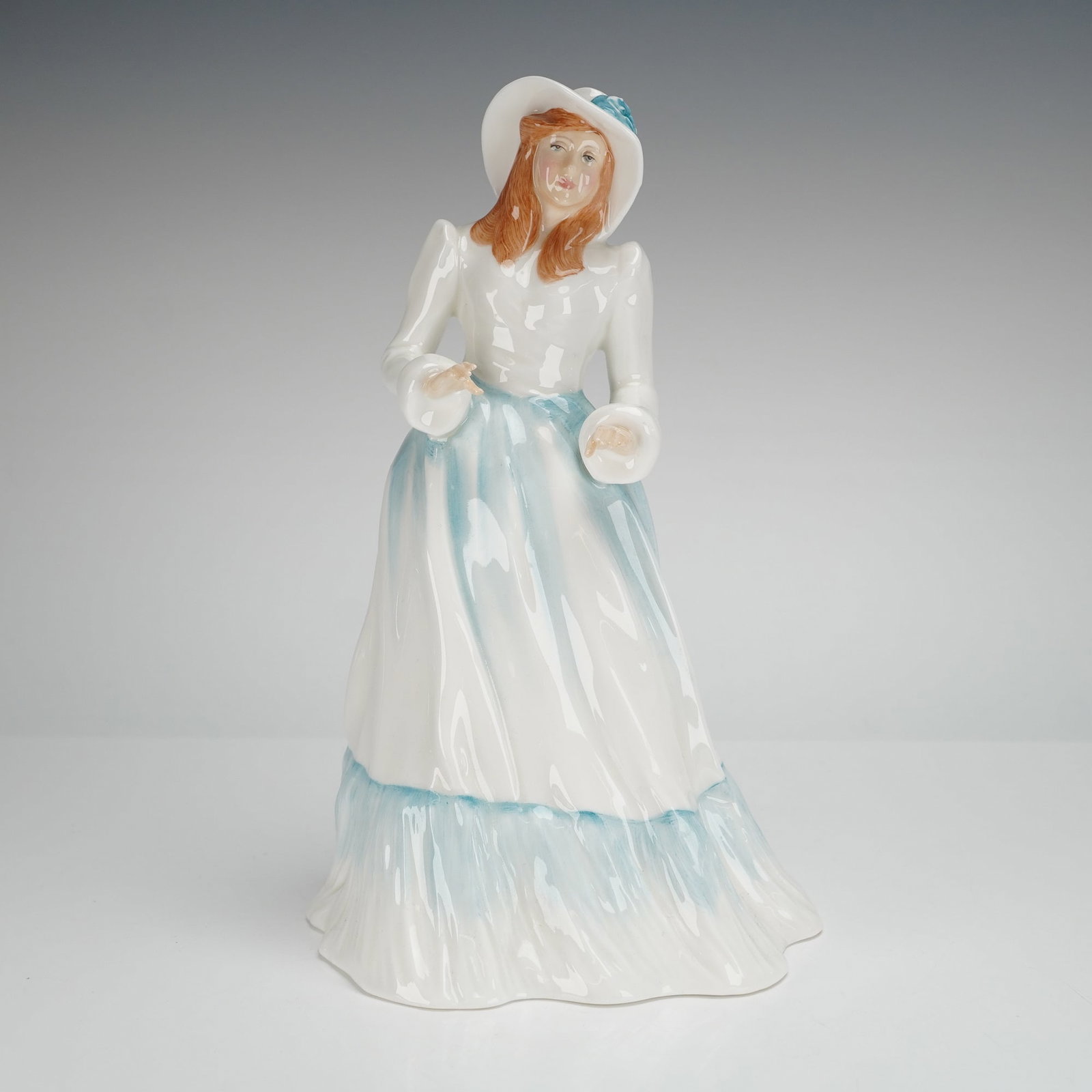 Royal Doulton Figurine Emily HN3204: Bone china figurine is part of the Vanity Fair Ladies Series, modelled by Adrian Hughes. The figure depicts a woman in a romanticized period dress and wide-brimmed hat, executed in a predominantly whi
