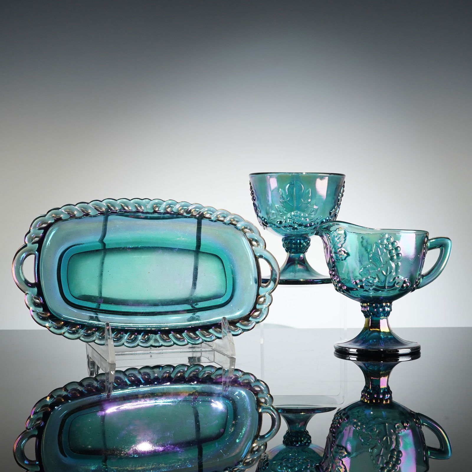Indiana Glass Harvest Grape Carnival Glass Creamer Sugar Tray: A three piece set of vintage Carnival Glass attributed to the Indiana Glass Co. in the Harvest Grape pattern. The set includes a footed sugar bowl, a handled and spouted creamer, and an oblong serving