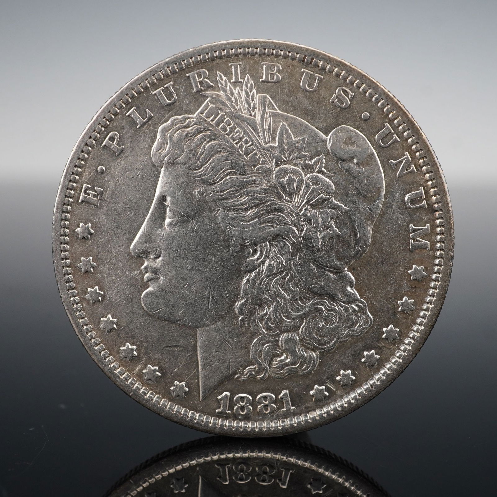 1881-S Morgan Silver Dollar: Struck at the San Francisco Mint in 1881, this Morgan Silver Dollar is composed of 90% silver. The obverse bears George T. Morgan's neoclassical rendering of Liberty, crowned with cotton blossoms and