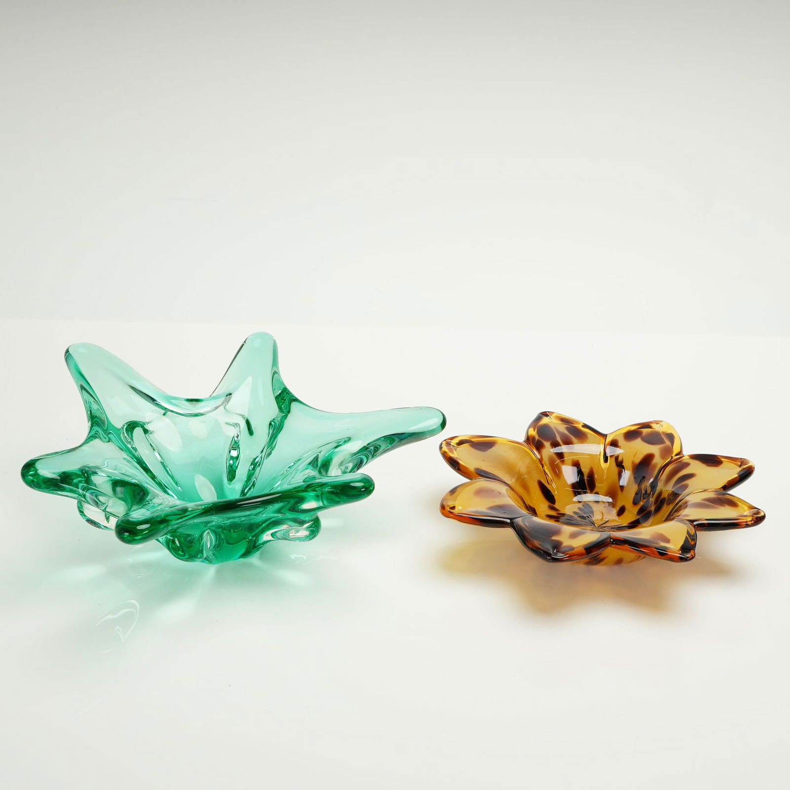 White Cristal Italian Art Glass Bowl and Freeform Glass Decorative Bowl: A pair of decorative art glass dishes crafted in styles associated with Murano glass techniques. The collection consists of two distinct items. The first item is a heavy, asymmetrical, six-pointed sta