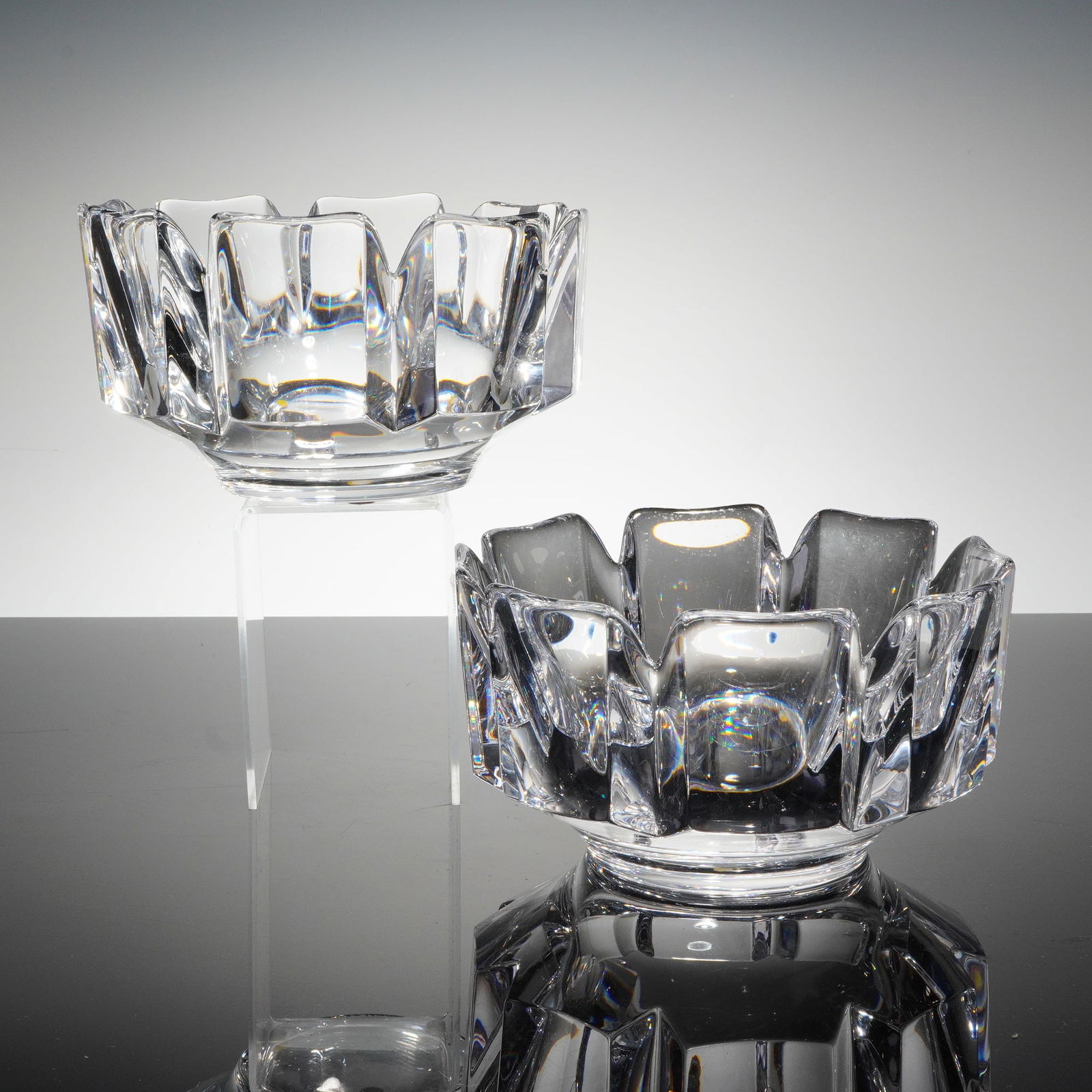 A Pair of Orrefors Corona Crystal Bowls by Lars Hellsten: A pair of heavy lead crystal bowls designed by Lars Hellsten for Orrefors, Sweden, in the 'Corona' patern. The modernist design features thick walls and deep, angular facet cutting creating a stylized