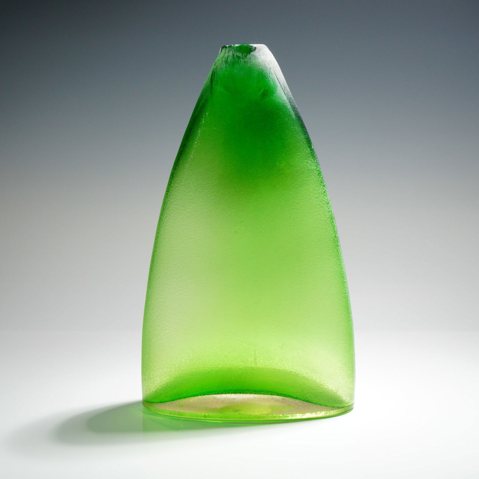 Modern Art Glass Sculptural Vessel, Inciso Technique: A single Modern Art Glass Sculptural Vessel crafted from thick glass exhibiting a gradient color shift from vibrant lime green at the base to a deep emerald green near the apex. The form is asymmetric