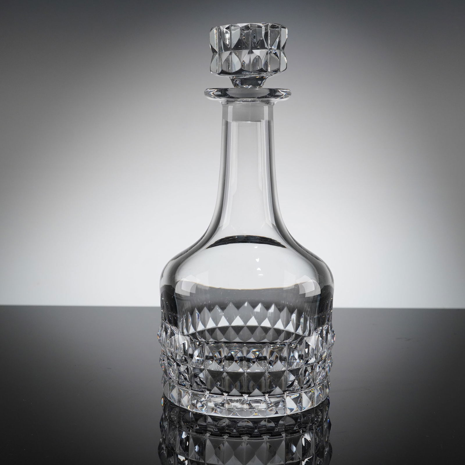 Orrefors Silvia Crystal Decanter Designed by Ingeborg Lundin: A single crystal decanter in the 'Silvia' patern, designed by Ingeborg Lundin for Orrefors. The vessel features a traditional form with a tall, narrow neck and is fited with a geometric faceted stoppe