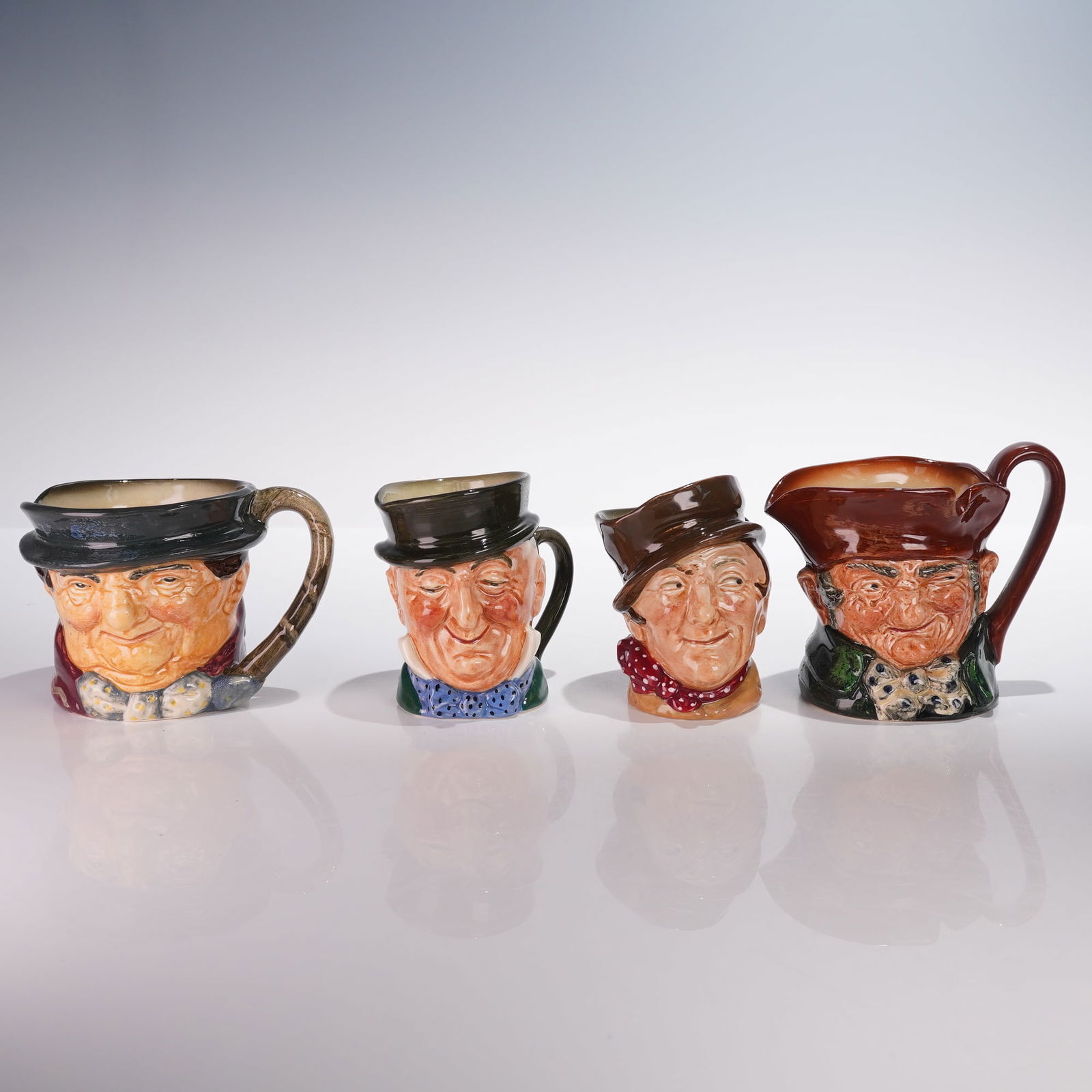 4pc Royal Doulton Character Jugs-Old Charley, Tony Weller, Micawber & D5841: A group of four Royal Doulton character jugs inspired by Charles Dickens' classic novels, including Old Charley D5527, Tony Weller D5530, Micawber D5843, and Sam Weller D5841. These mid 20th century j