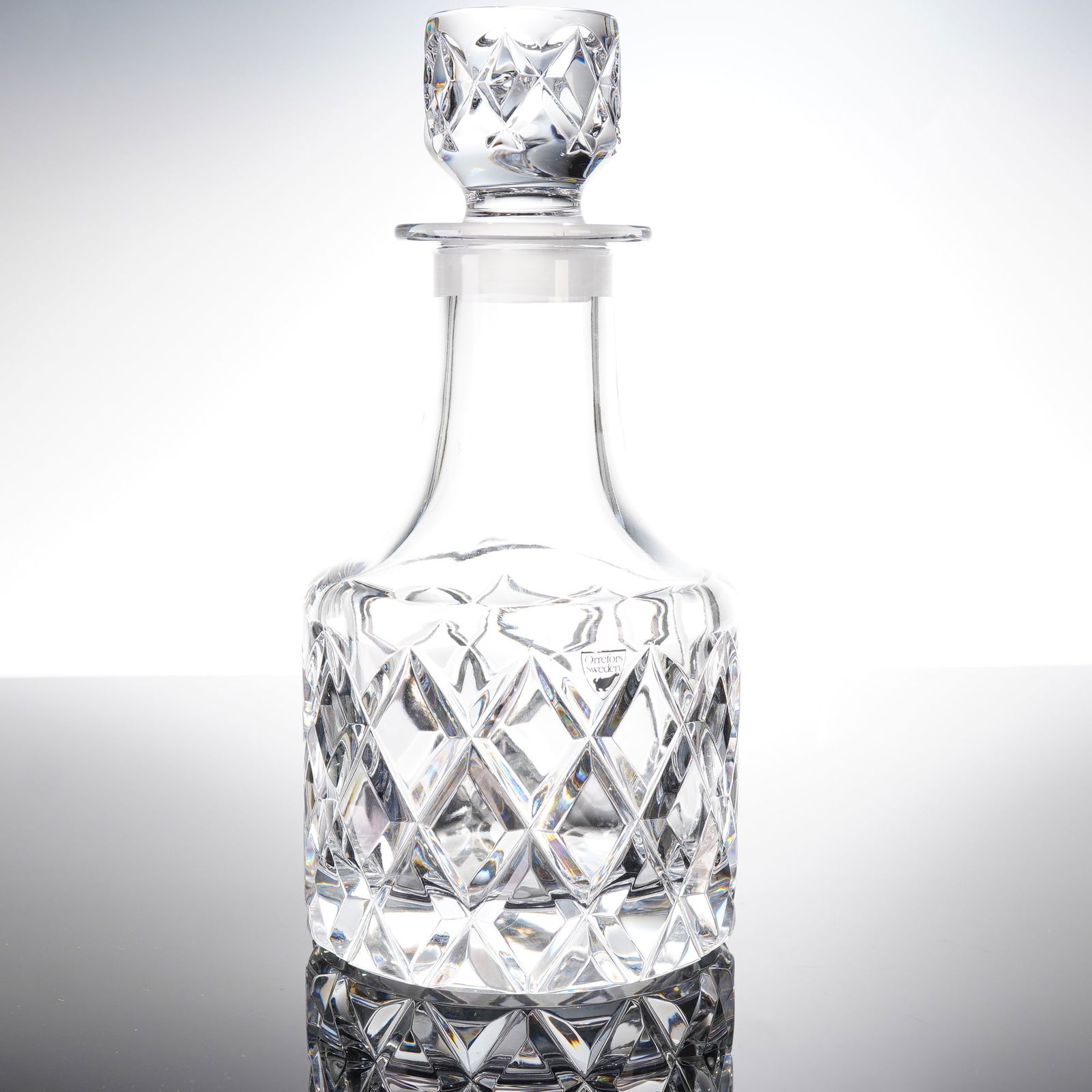 Orrefors Sofiero Crystal Decanter: A modern cut crystal decanter produced by the Swedish glass house Orrefors in the Sofiero patern. The decanter is constructed of heavy, clear crystal and includes its original fited stopper. The body