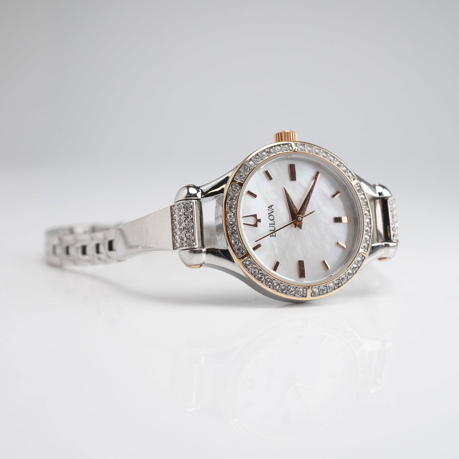 Bulova Ladies Model 98L262 Quartz Watch with Mother of Pearl Dial: A contemporary ladies' Bulova quartz wristwatch, Model 98L262, featuring a stainless steel case and integrated link bracelet. The watch is distinguished by a shimmering mother of pearl dial accented b