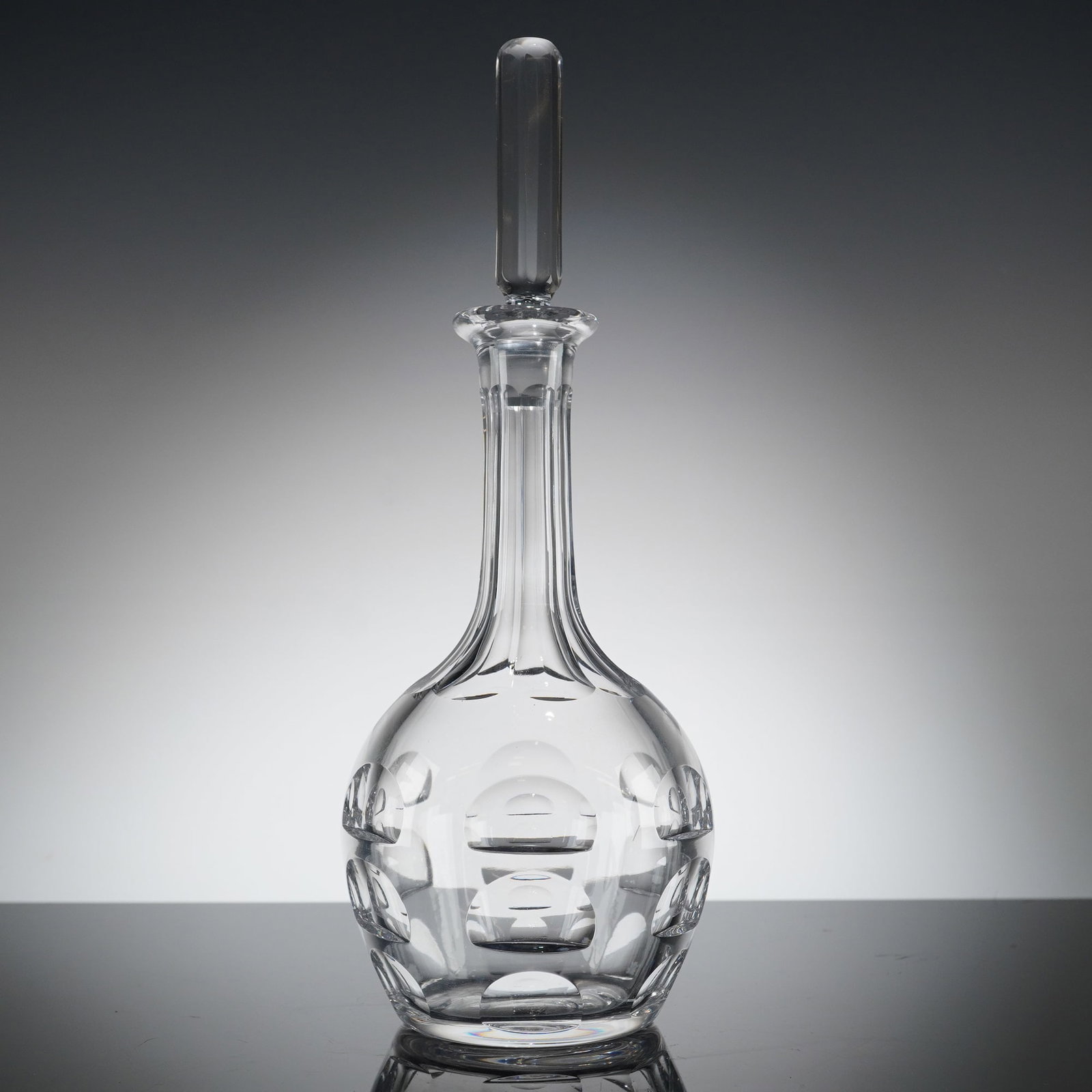Orrefors Crystal Bernadote Decanter and Stopper: A two-item set comprising a tall, clear colorless cut glass or crystal decanter and its matching bar-style stopper. The decanter features a bulbous body deeply cut with horizontal rings alternating wi