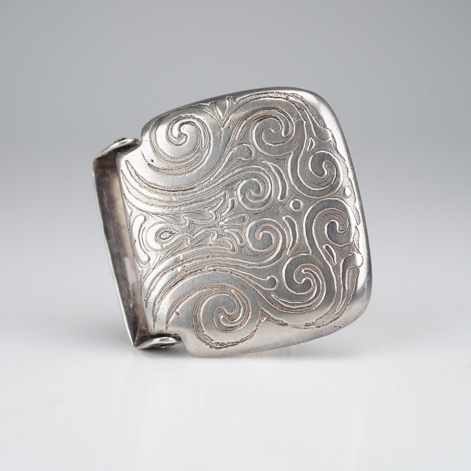 Tiffany & Co Sterling Silver Monogrammed Belt Buckle: A sterling silver belt buckle manufactured by Tiffany & Co. The object is constructed in a hinged, rectangular form with rounded corners, designed for use as a belt or sash buckle. The reverse side is