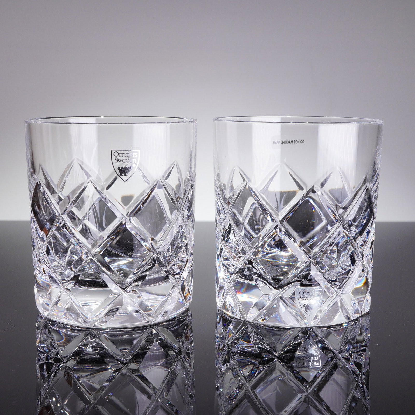 A Pair of Orrefors Sofiero Crystal Double Old Fashioned Glasses: A pair of Orrefors crystal Double Old Fashioned glasses in the Sofiero patern. These 2pc Orrefors Crystal Old Fashioned glasses are executed in clear, brilliant crystal. Each glass features a heavy, s
