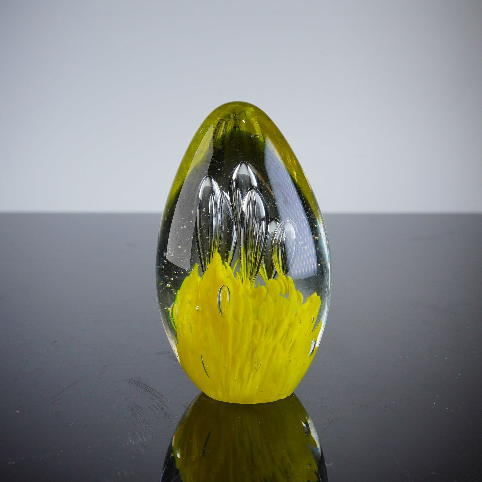 Murero Italy Art Glass Egg Paperweight: A contemporary Murero art glass paperweight, crafted in an ovoid or egg shape. The piece features a clear glass exterior casing encasing a vibrant internal structure. The interior decoration consists