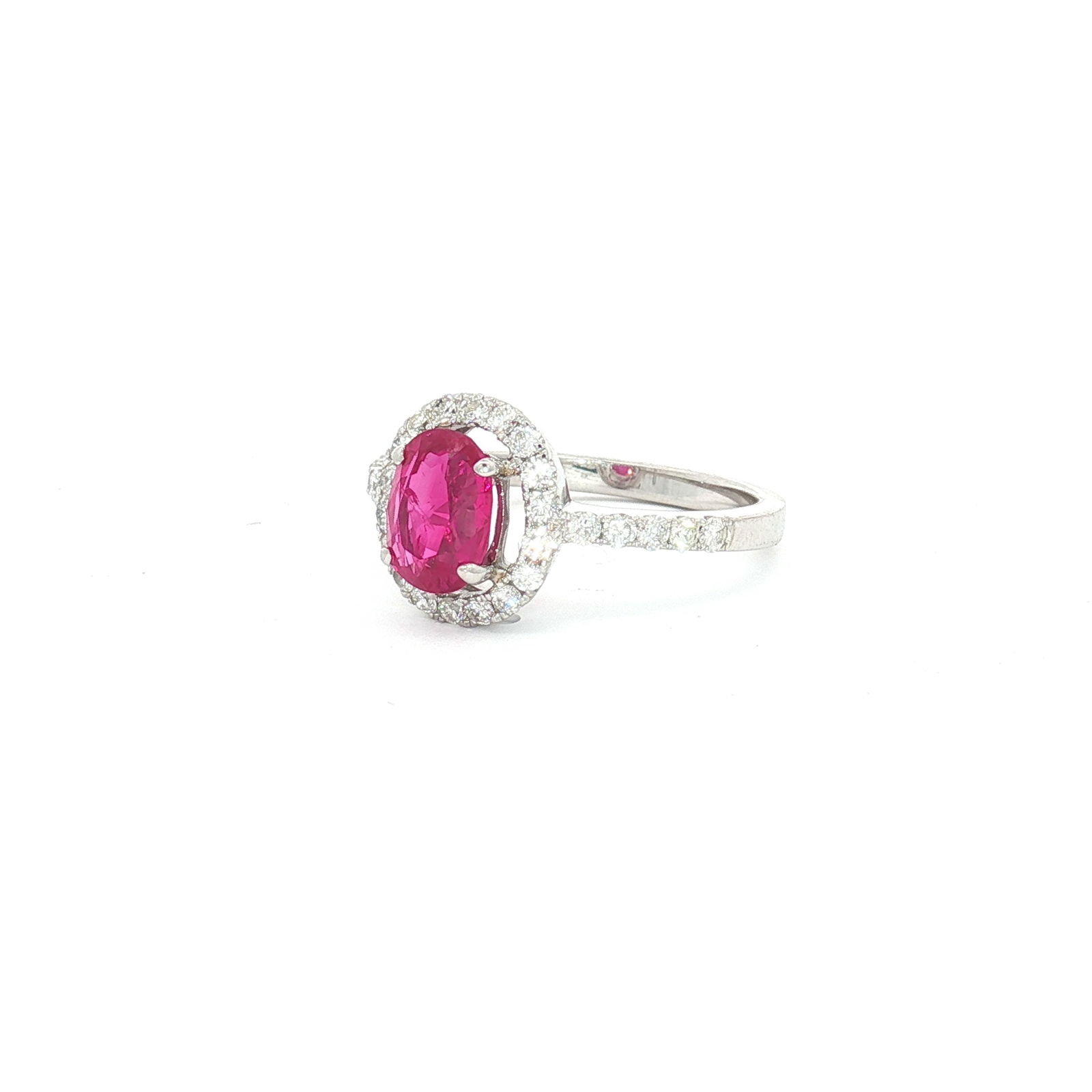 18K White Gold, 1.44ct Burma Oval Ruby and 0.46ctw Diamond Ring: An 18k white gold ring featuring a central oval-cut Burma ruby. The gemstone is secured in a four-prong setting and surrounded by a halo of round brilliant-cut diamonds. The shoulders of the band are