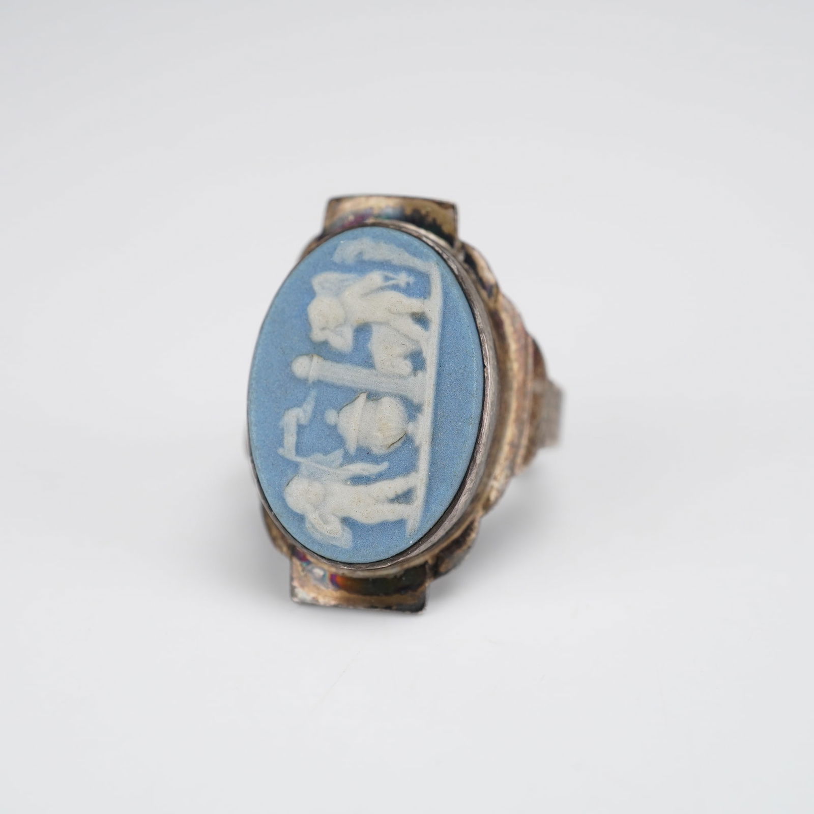 Wedgwood Blue Jasperware Cameo Adjustable Sterling Silver Ring: A single sterling silver adjustable finger ring featuring an oval blue and white jasperware cameo plaque, attributed to Wedgwood. The plaque displays a Neoclassical scene in white bas-relief against a