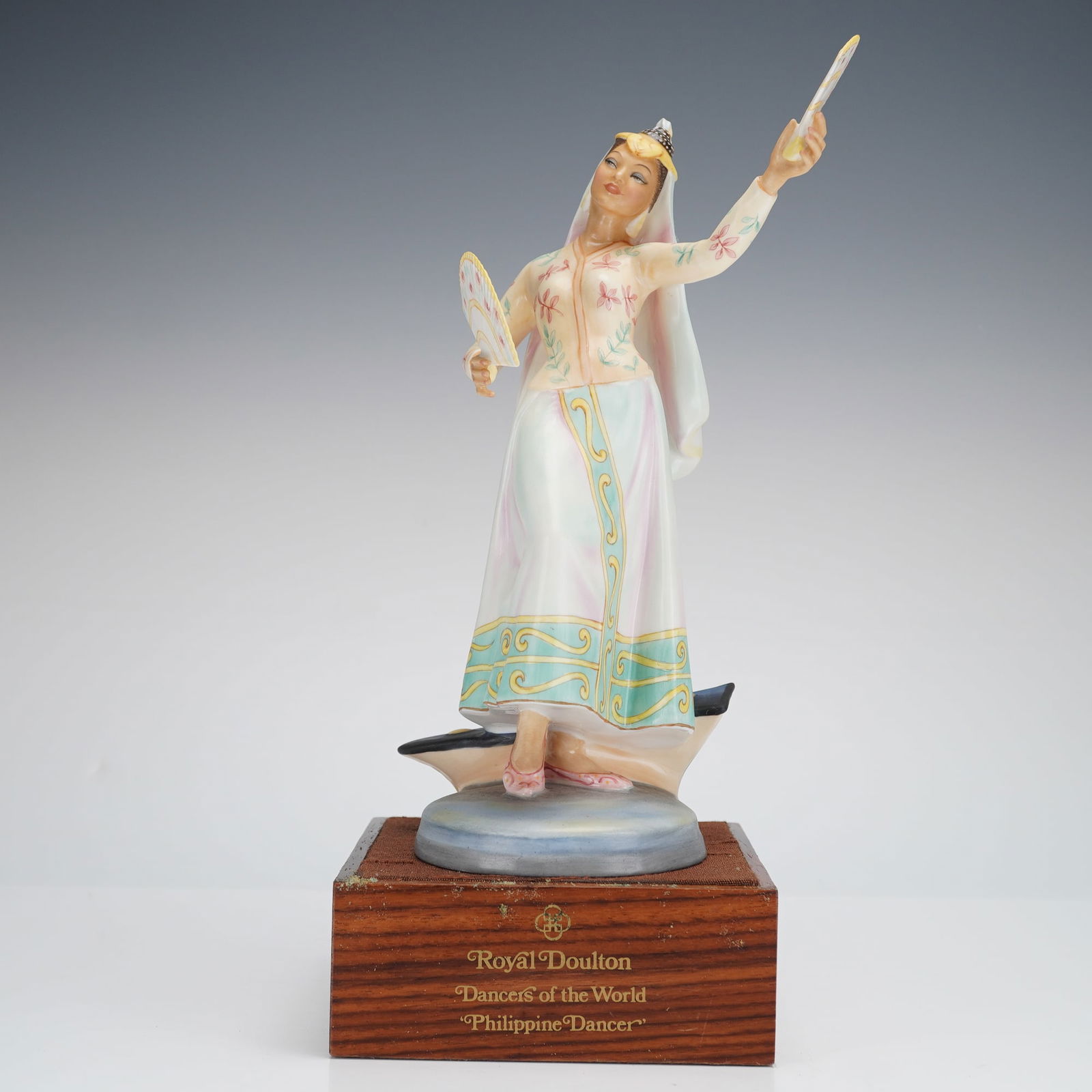 Royal Doulton Figurine Philippine Dancer HN2439: A porcelain figurine by Royal Doulton, titled "Philippine Dancer" (Model HN 2439) from the "Dancers of the World" series. The piece is rendered in pastel tones including white, pink, teal, and yellow.