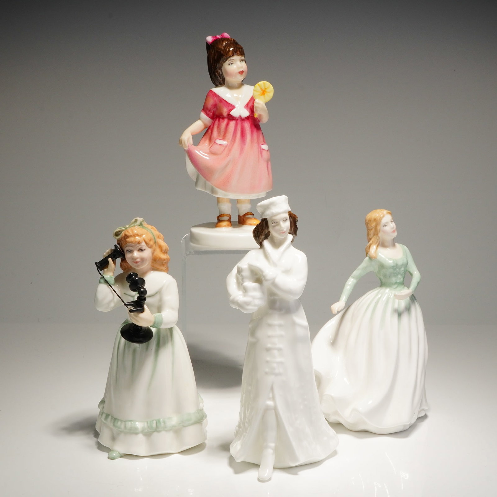 4pc Royal Doulton Bone China Figurines: A grouping of four Royal Doulton Bone China Figurines including Special Treat (HN3663), Hello Daddy (HN3651), Noel (HN4084), and From the Heart (HN4454). The underside of ach figurine features the Roy