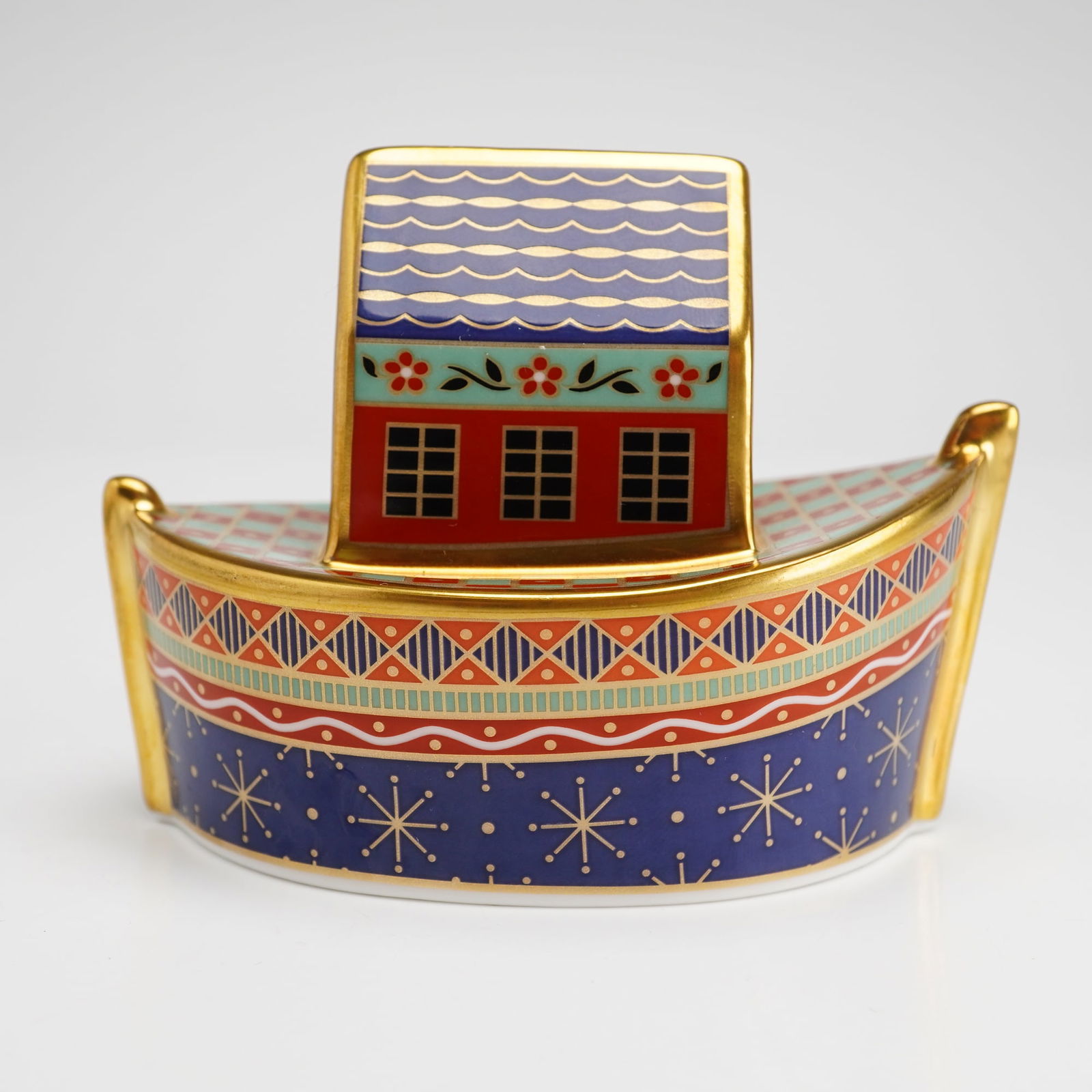 Royal Crown Derby Paperweight, Noah's Ark: The figurine is modeled in the form of an ark and features polychrome enamel decoration. The motifs include a zebra, a spotted elephant, and a bird, set against a variety of geometric and floral patte