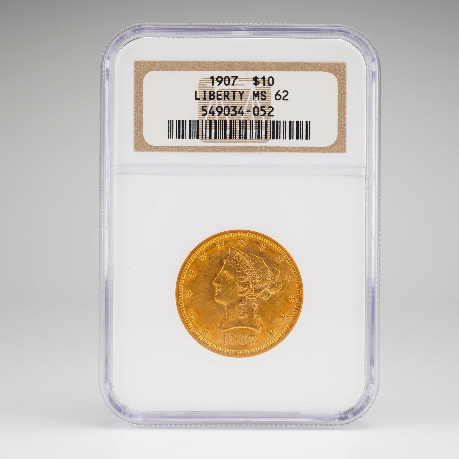 1907 $10 Liberty Head Gold Coin, NGC MS62: Graded NGC MS62 and slabbed for protection, features the iconic obverse design by Christian Gobrecht depicting Liberty in coronet facing left, surrounded by 13 stars with the date below. The reverse,