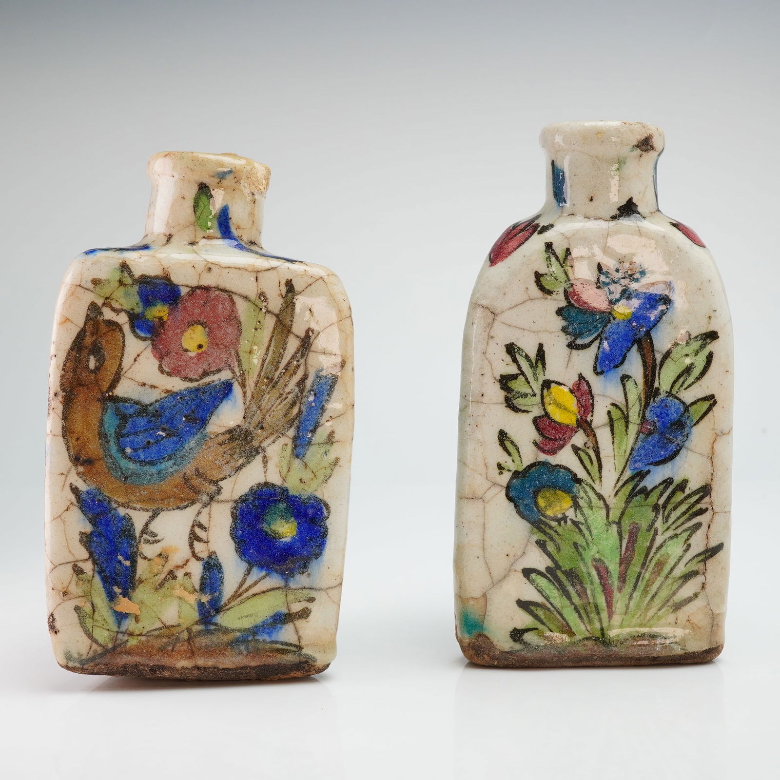 2pc Antique Persian Qajar Iznik Pottery Bottles, Triangle Bird & Floral: Persian pottery bottles, attributed to the Qajar period and decorated in the Iznik-inspired geometric style. The triangle bottle pair are hand-painted with stylized with bird and floral designs, Execu
