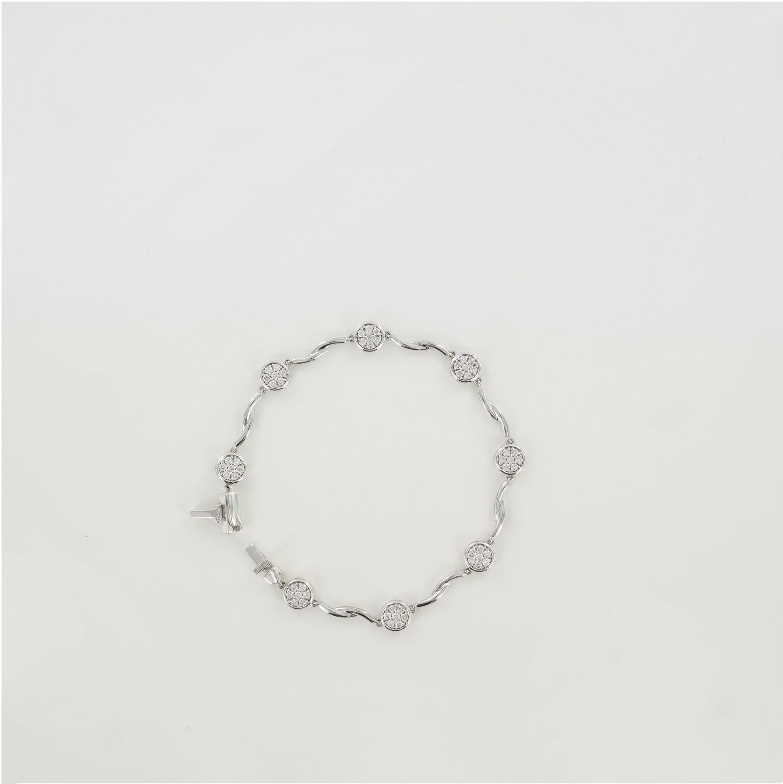 14K White Gold 1.03ctw Diamond Bezel Cluster Bracelet: A stylish 14K white gold bracelet featuring round-cut white diamonds totaling approximately 1.03 carats. Each diamond cluster is securely bezel-set, connected by graceful curved links that add movemen