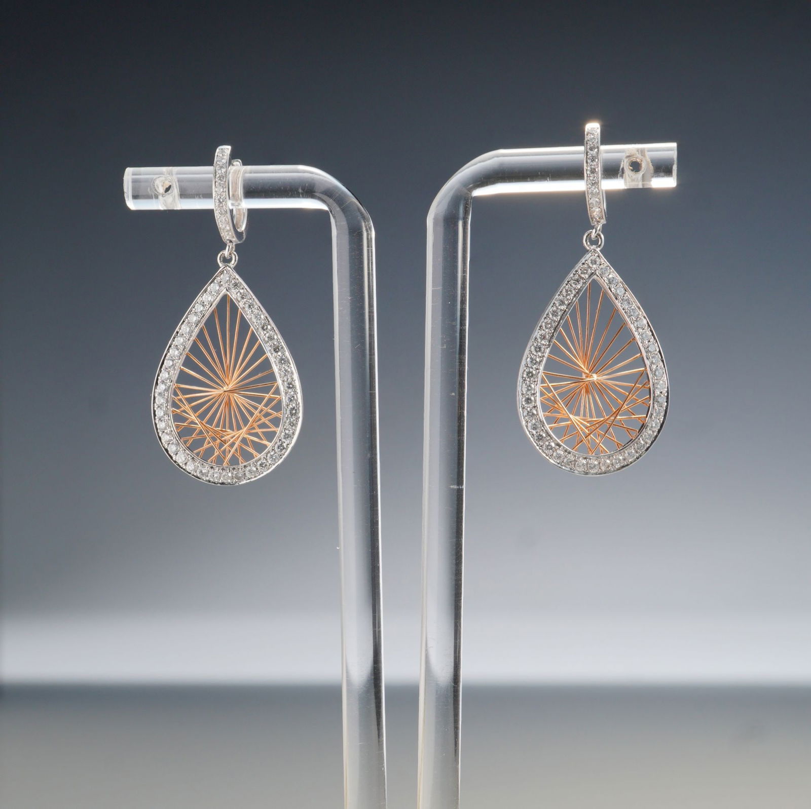 Pair of 14K Two-Tone Gold 1.10ctw Diamond Teardrop Dangle Earrings: A striking pair of 14K two-tone gold dangle earrings featuring teardrop-shaped drops outlined in white gold and accented with round white diamonds totaling approximately 1.10 carats. The intricate inn