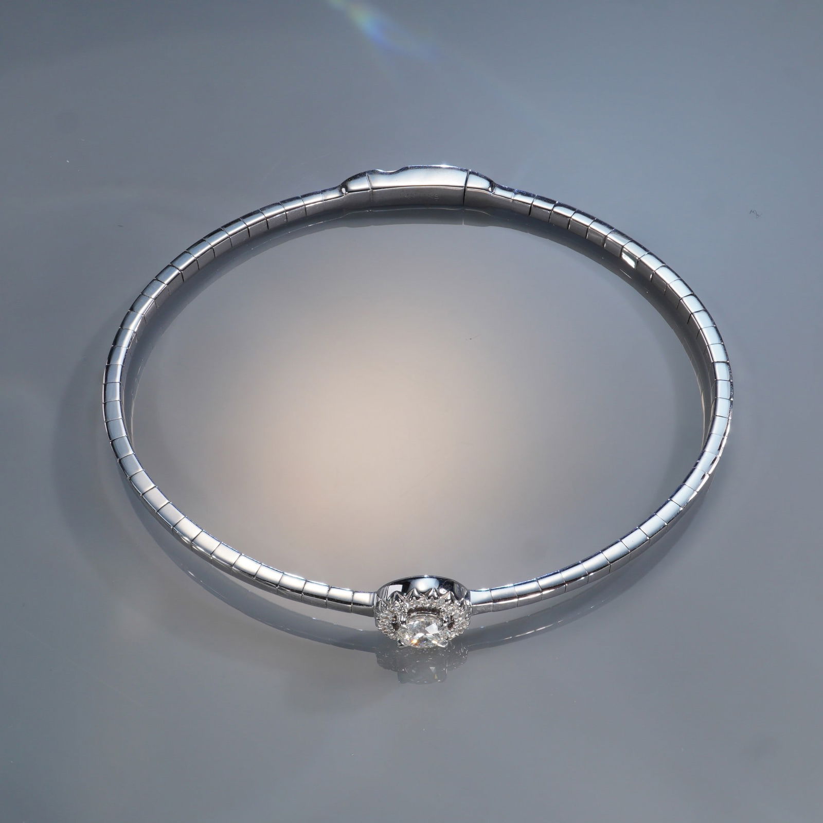 14K White Gold 0.50ctw Diamond Round Bangle: A refined 14K white gold bangle set with a brilliant 0.50 carat total weight of white diamonds. The centerpiece features a sparkling round-cut diamond surrounded by a halo of smaller diamonds, enhanci
