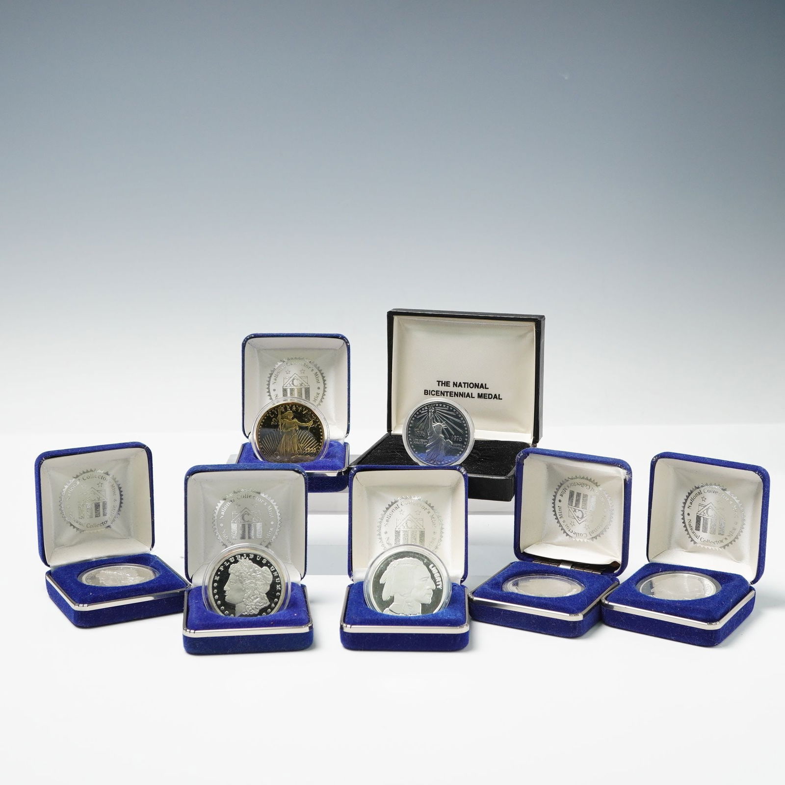 7pc National Collectors Mint Silver Replica Rounds and Medal: Includes two 1889 Morgan Silver Dollar replicas designed with Liberty head facing left on the obverse and an eagle holding arrows and an olive branch, within wreath, along with the serial number on th