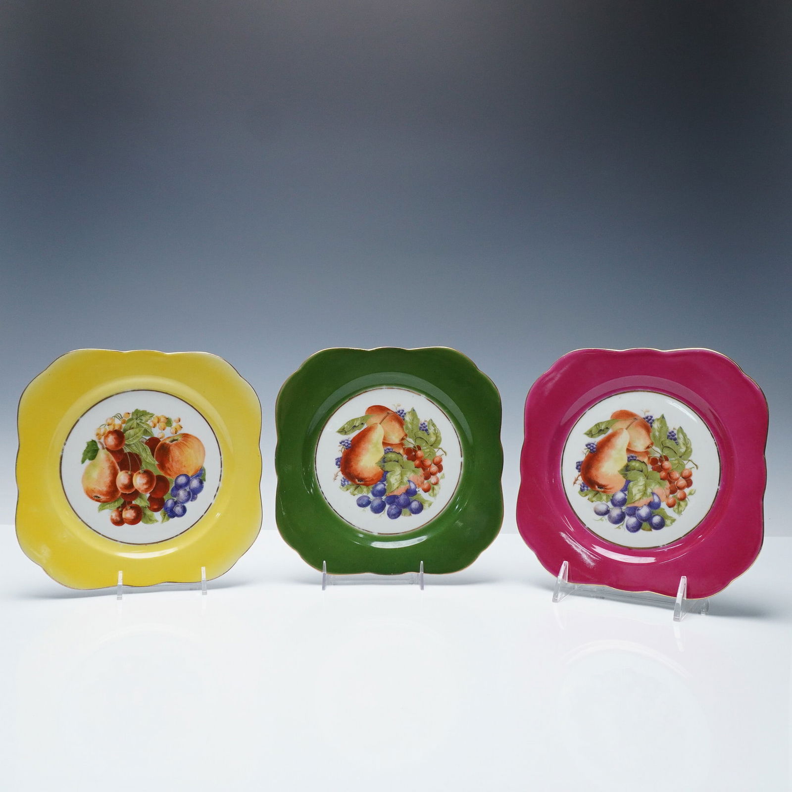 3pc M&R France Hand-Painted Fruit Motif Plates: Set of three vintage M & R France porcelain plates, each featuring a vibrant hand-painted fruit motif at the center, framed by a bold scalloped rim in yellow, green, and pink. The beautifully detailed