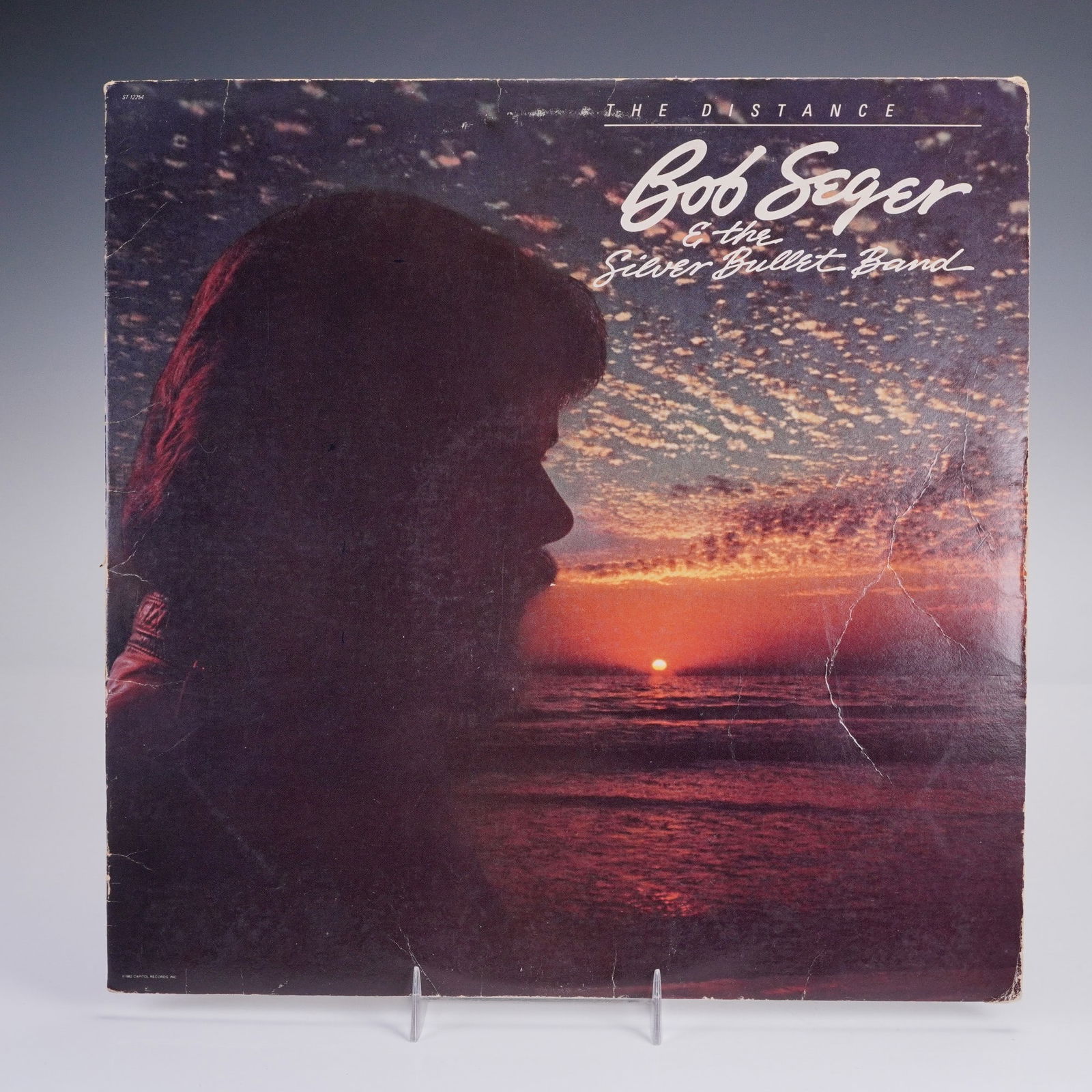 Bob Seger and the Silver Bullet Band Vinyl Record, The Distance: A classic vinyl of Bob Seger and the Silver Bullet Bands The Distance, pressed on black vinyl with an orange label, with the front showing a moody silhouette against a glowing sunset sky, and the back