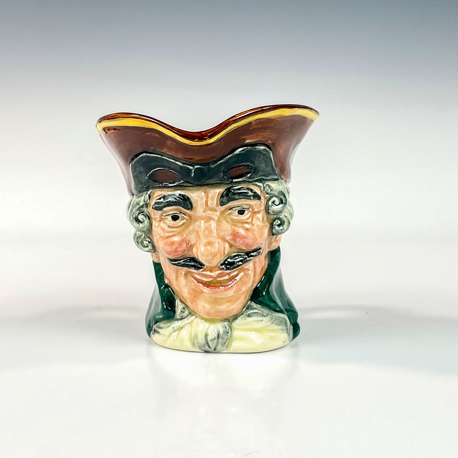 Dick Turpin D5618 Small Doulton Character Jug: Style One. Brown hat; black mask up; green coat; white cravat. Dick Turpin (1705 - 1739) joined forces with fellow highwayman Tom King, whom he accidentally shot. Before he died, King betrayed him. Th