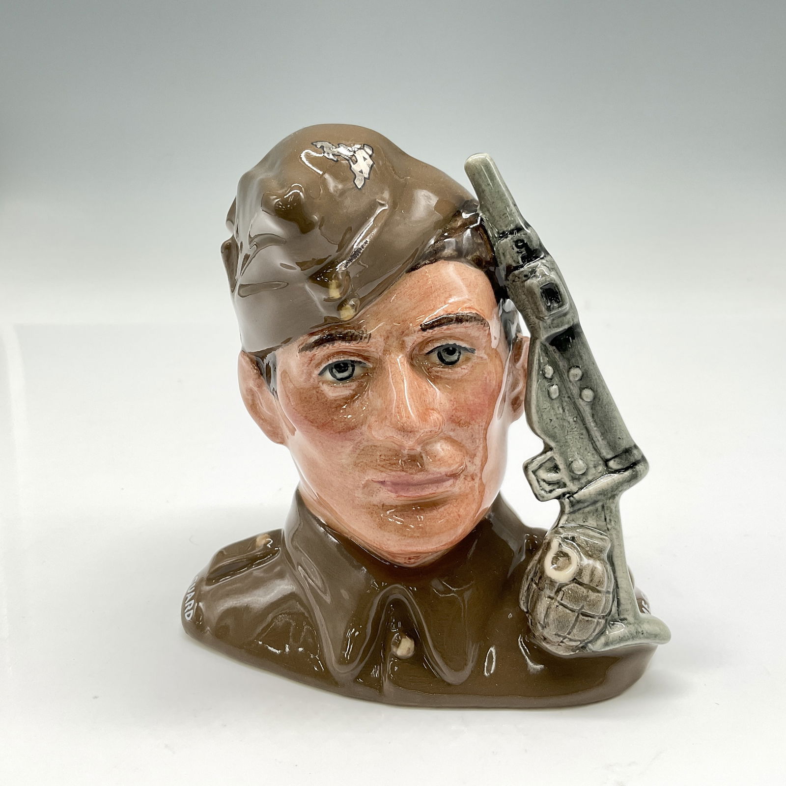 Home Guard D6886 - Small - Royal Doulton Character Jug: Style One, sten gun and hand grenade handle. Khaki uniform and cap. Royal Doulton backstamp. Artist: Stanley J. Taylor Issued: 1991 Dimensions: 4.5"H Edition Number: 219 of 9500 Country of Origin: