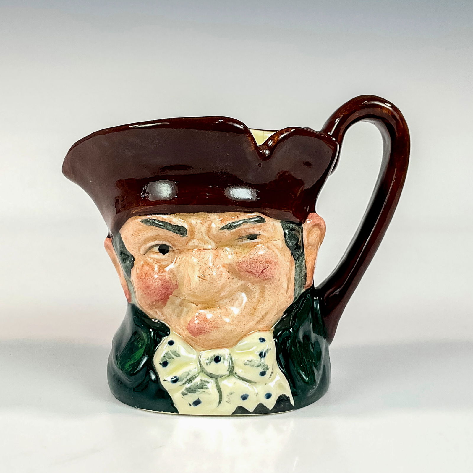 Old Charley D5527 - Small - Royal Doulton Character Jug: Brown hat; dark green coat; blue polka- dot bow tie. " Ten o'clock and all's well" was the familiar call of the Charlies, watchmen who originated during the reign of Charles II and were named after hi