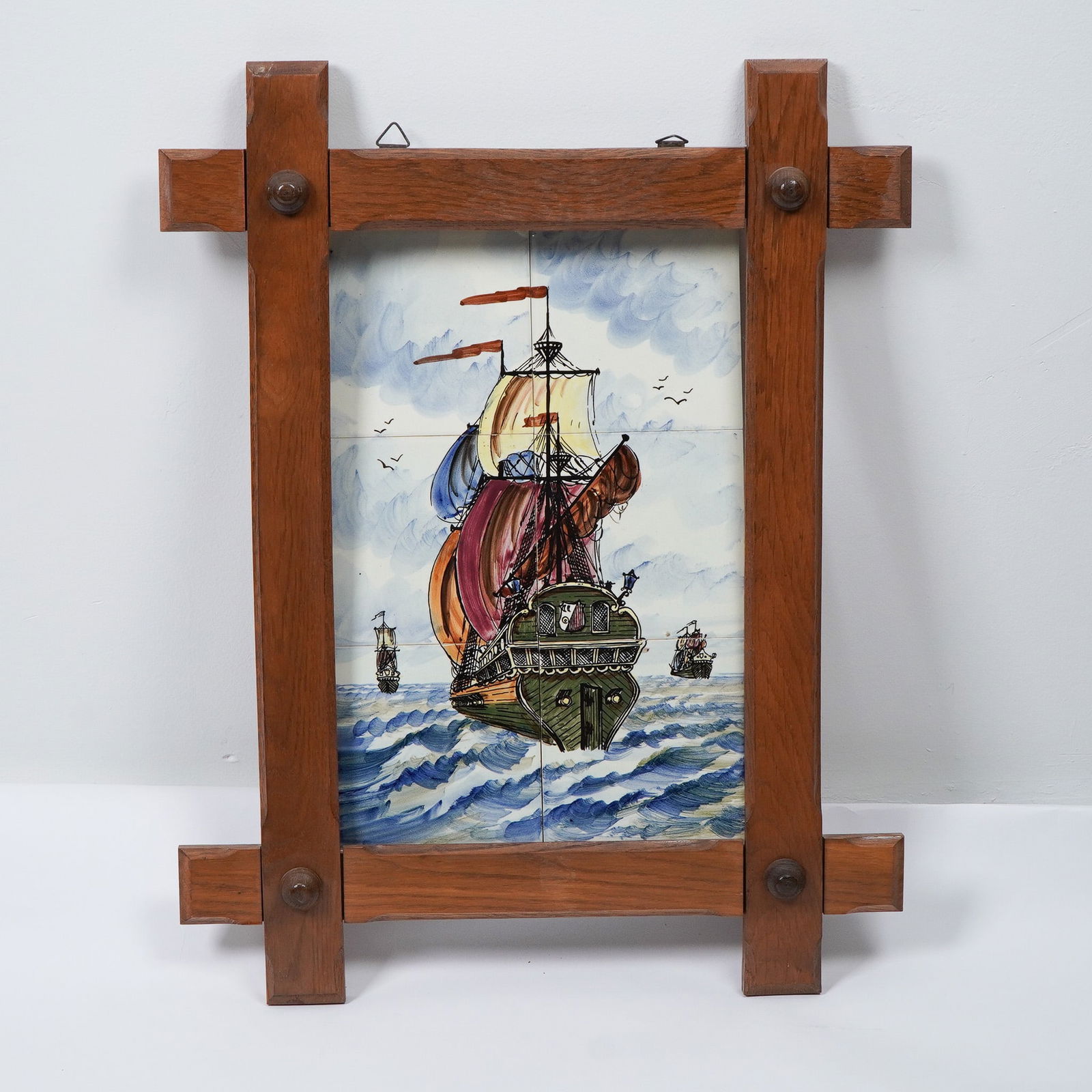 Tile Mural Ship at Sea: This striking 6-tile artwork features a majestic tall ship sailing through the open seas, framed in a rustic wooden structure with metal accents. The vibrant colors bring the maritime scene to life, s