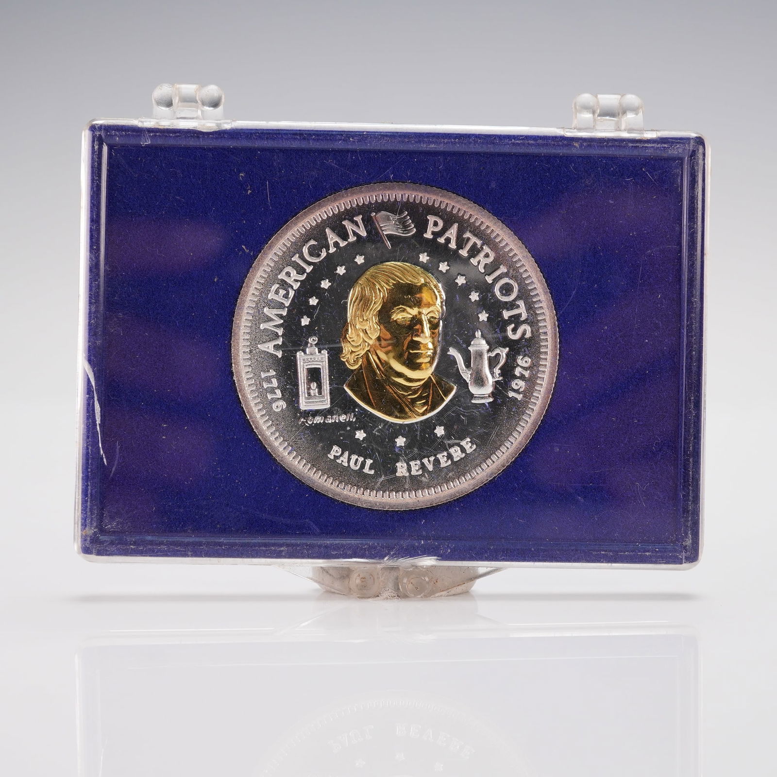 1976-L Paul Revere American Patriots Bullion: A portrait of Paul Revere on the obverse, flanked by a lantern and a teapot, with inscriptions AMERICAN PATRIOTS, 1776, and PAUL REVERE. The reverse displays a wreath encircling the inscriptions VINCI